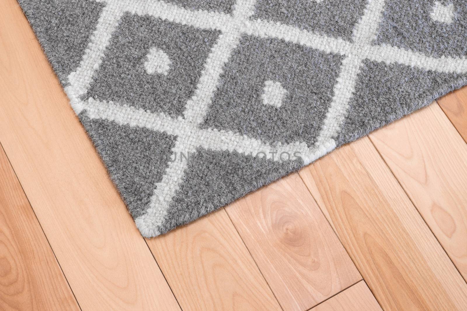Contemporary gray wool rug on wooden floor.