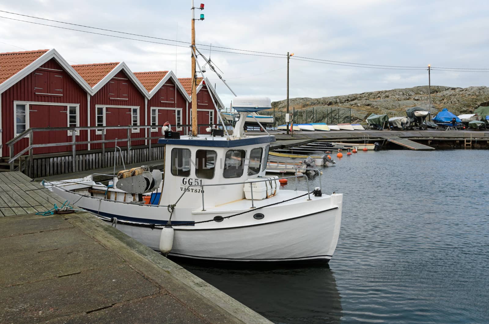 lonely small fishing boat in the harbor on a winter Klädesholmen