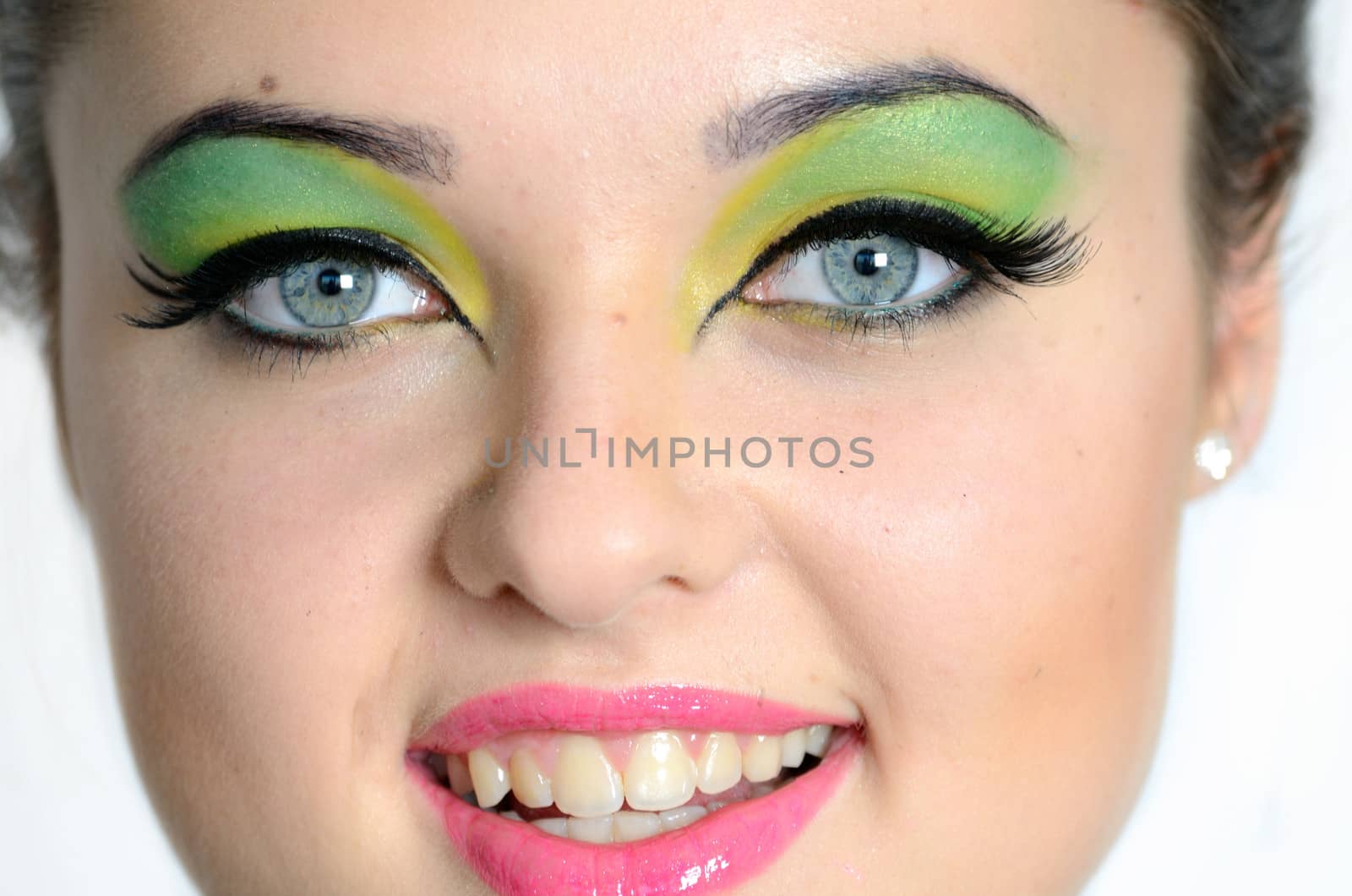 Smiling face photo of young female model with colorful make-up. Young girl with cheering smile.