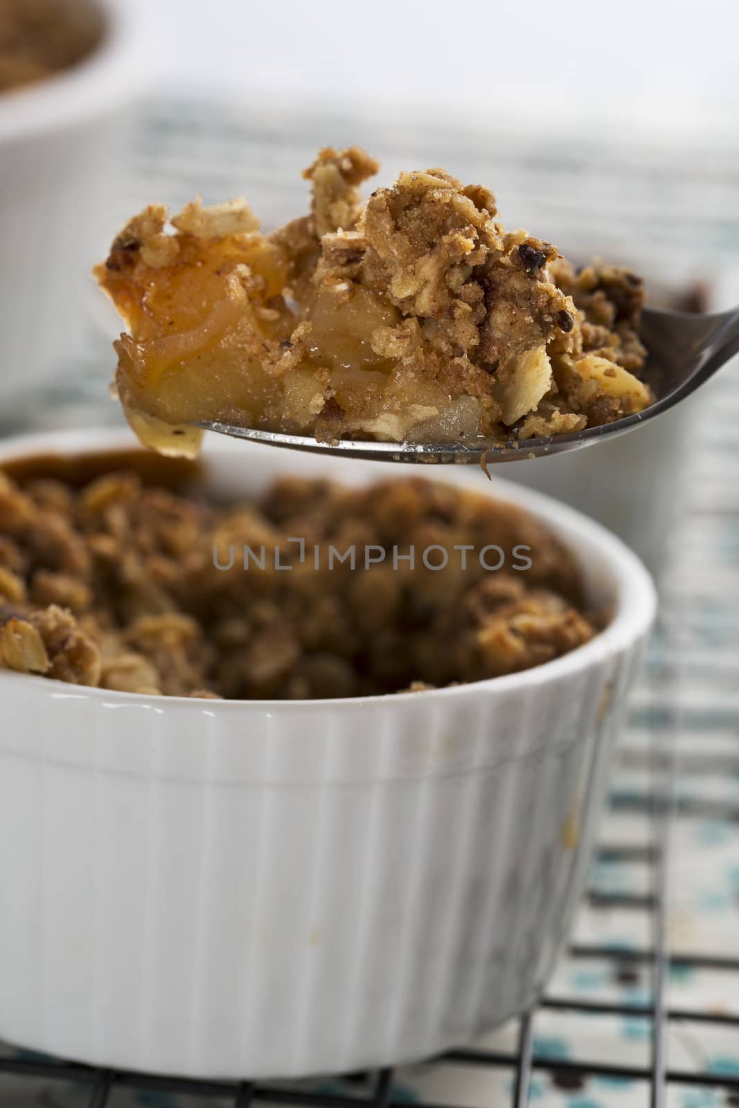 Spoon full of fresh apple crumble from single serving