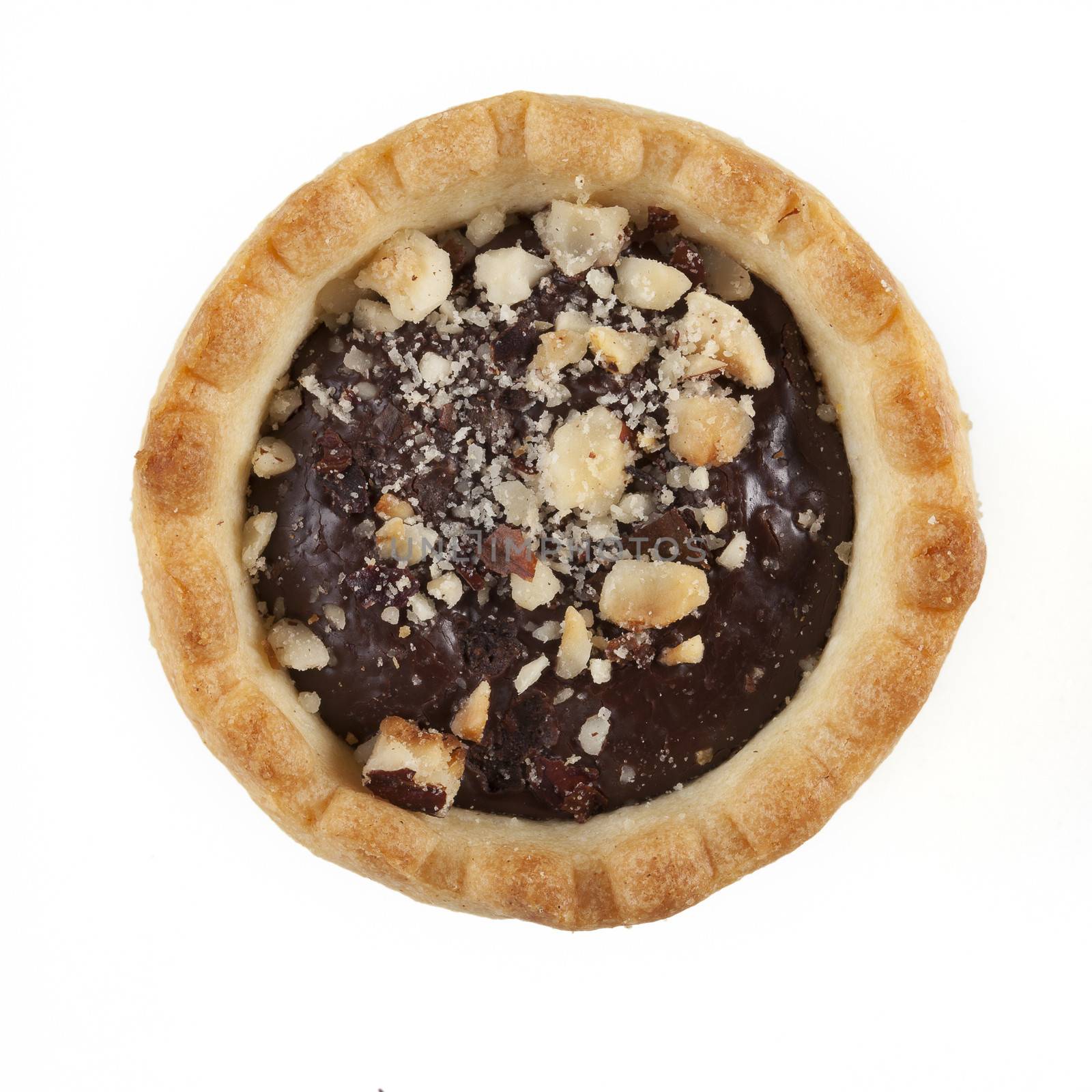One chocolate tart sprinkled with chopped nuts on white background