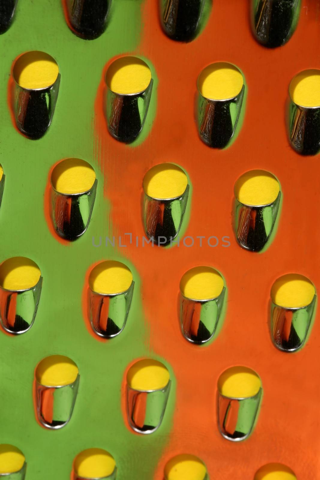 Macro view of a stainless steel cheese grater with reflected colors