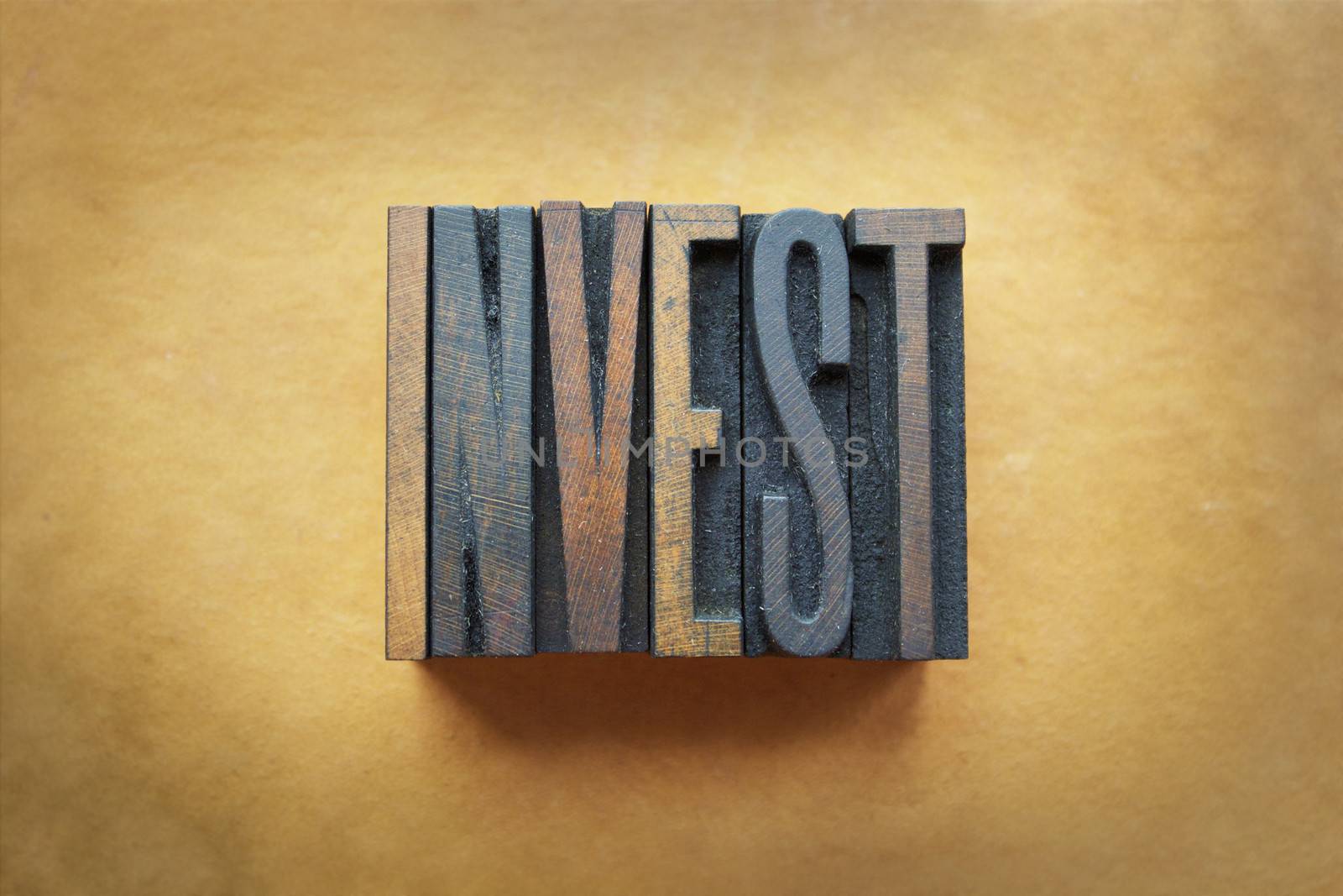 The word INVEST written in vintage letterpress type.