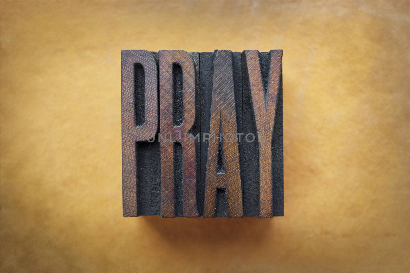 The word PRAY written in vintage letterpress type.