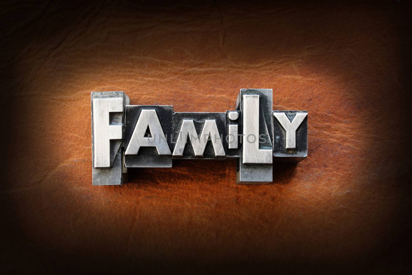 The word family made from vintage lead letterpress type on a leather background.