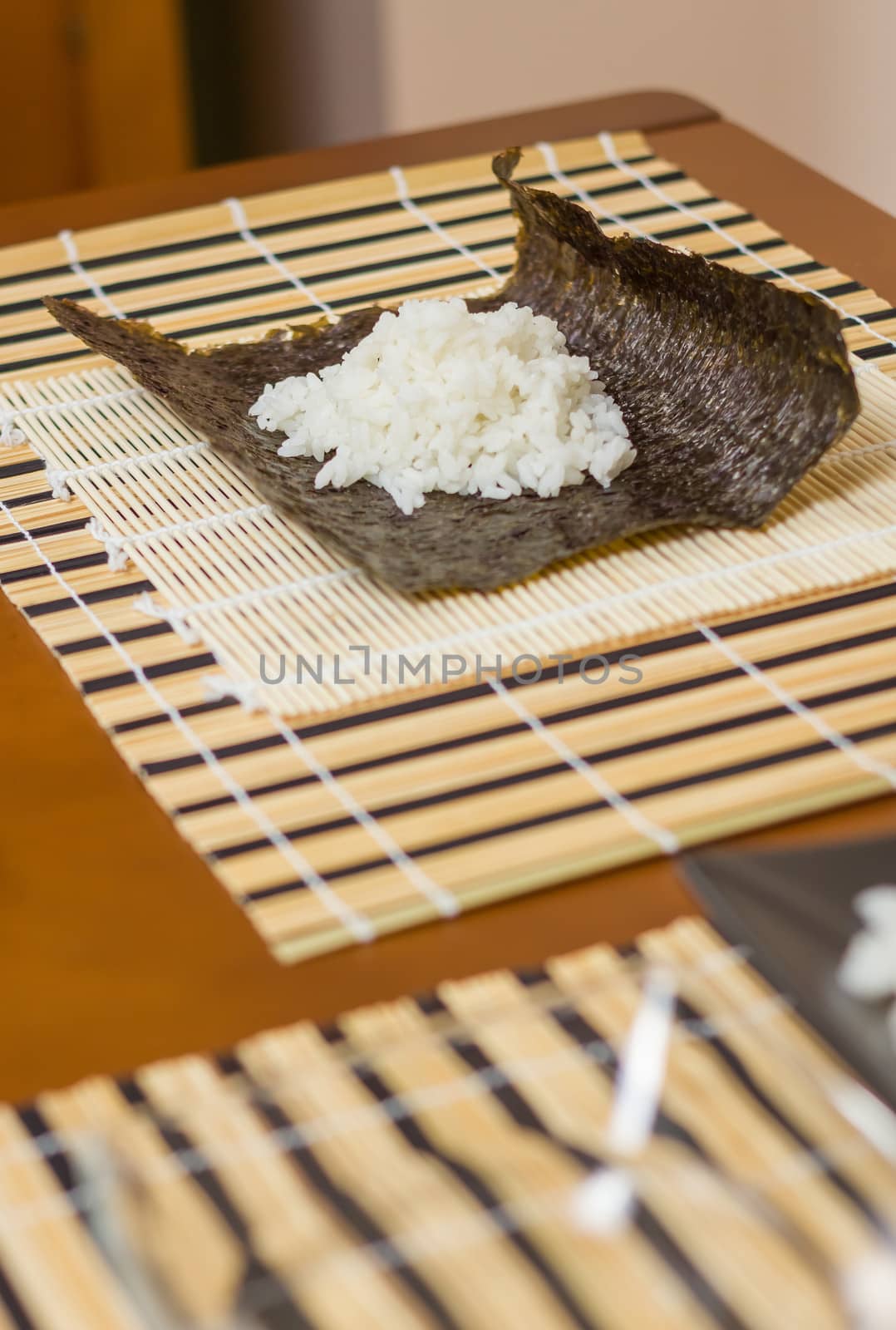 Nori seaweed sheet with rice above ready to make japanese sushi rolls