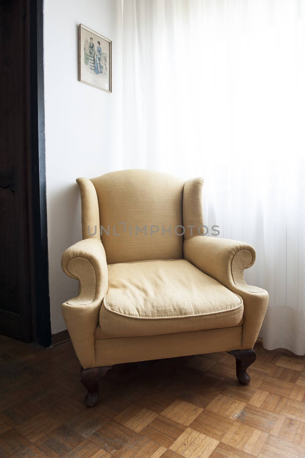 A brown armchair in an old apartment with wooden floor