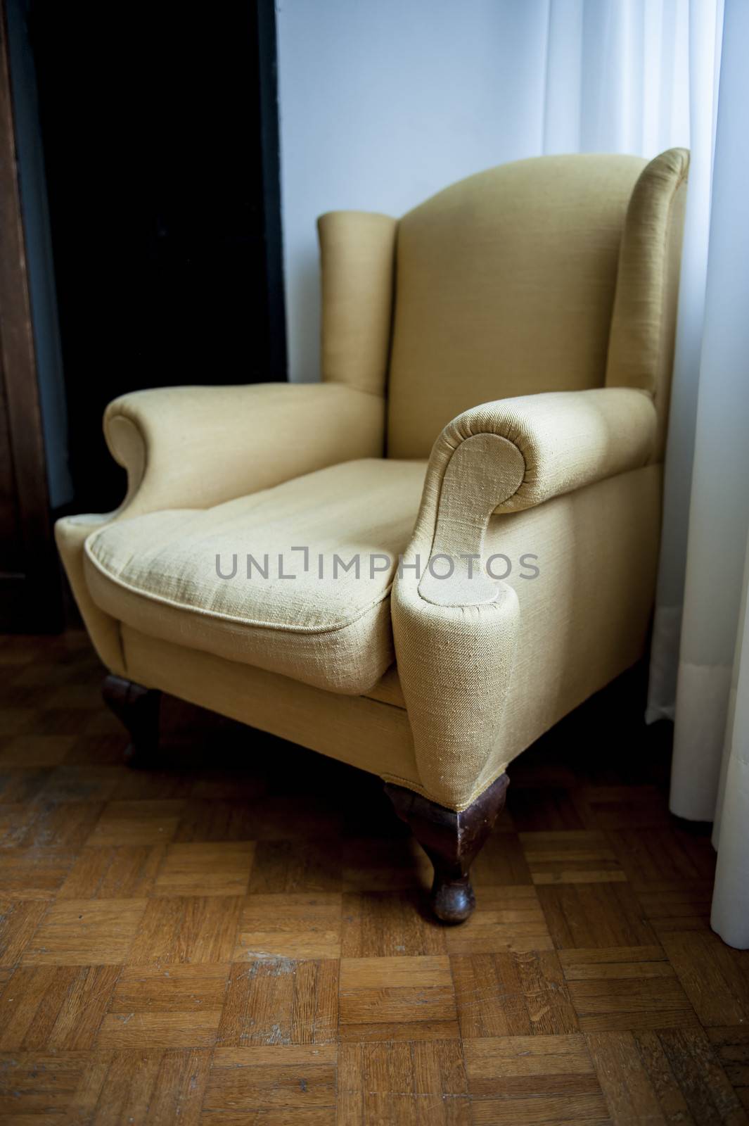 A brown armchair in an old apartment with wooden floor