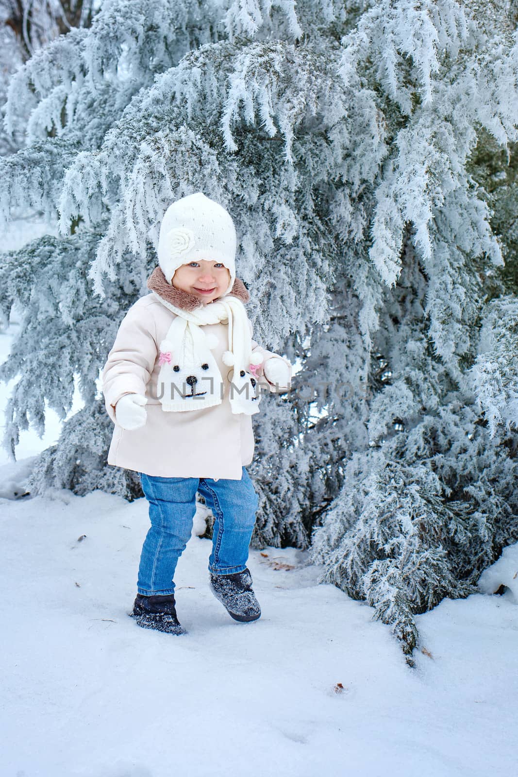 Little cute girl walking in winter forest alone