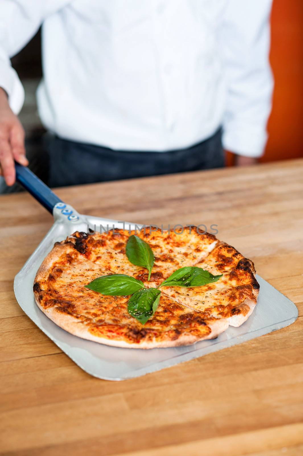 Cropped image of a chef preparing pizza