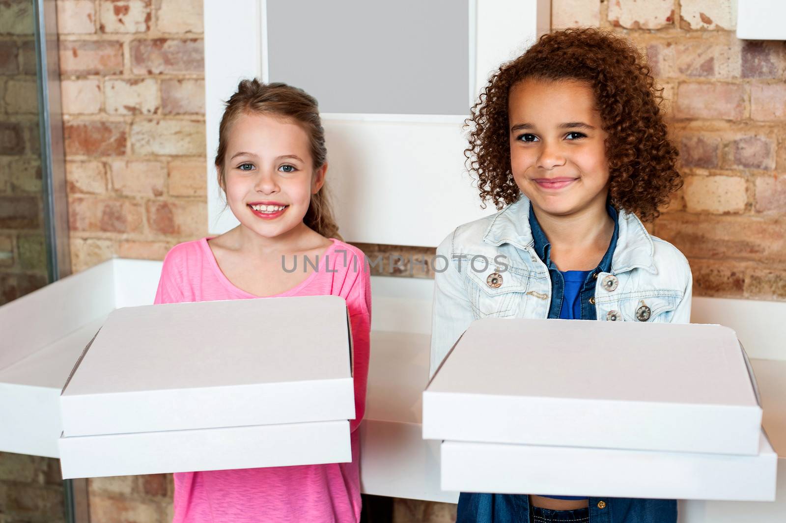 Kids holding pizza boxes by stockyimages