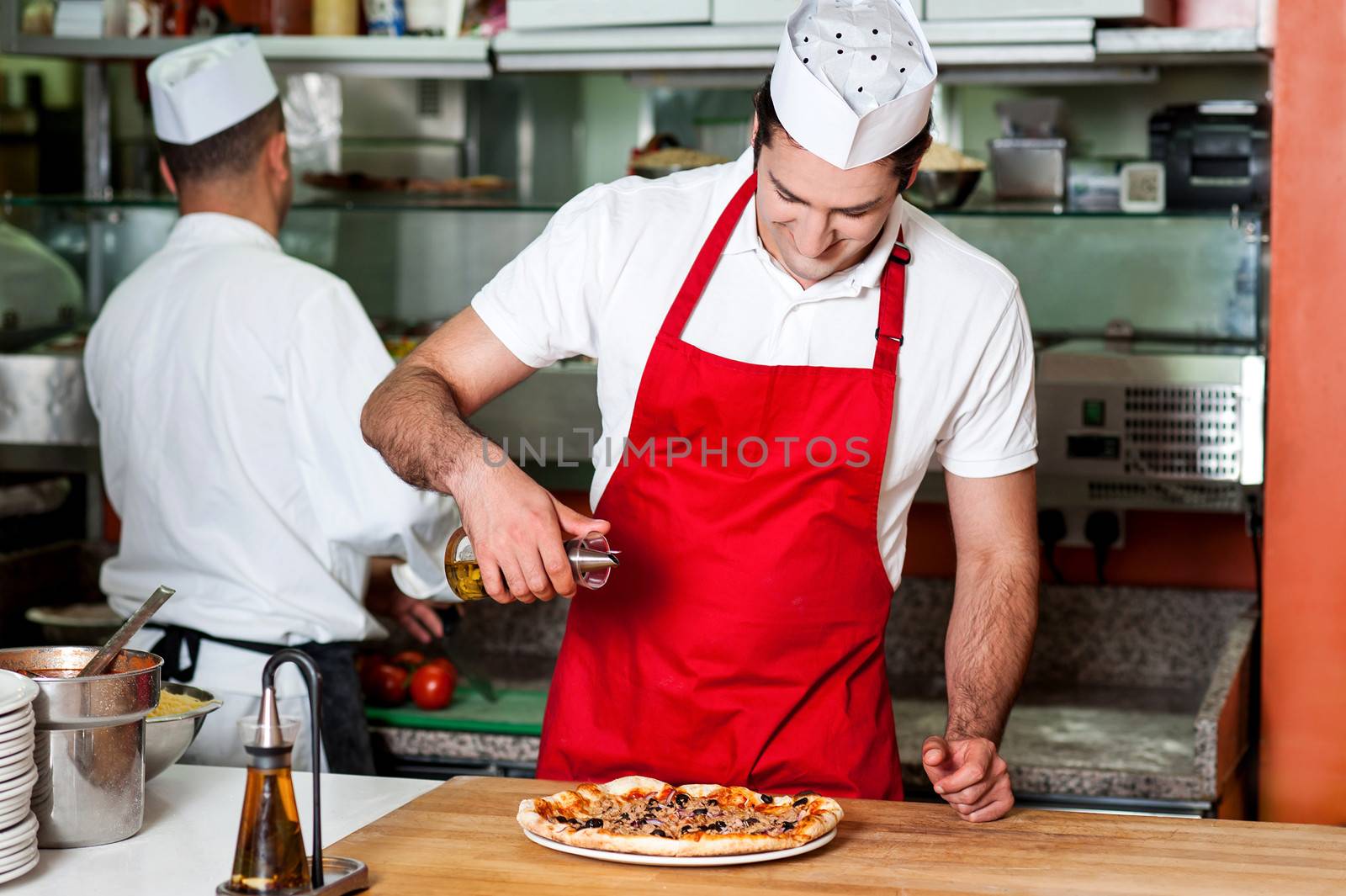 Chefs at work inside restaurant kitchen by stockyimages