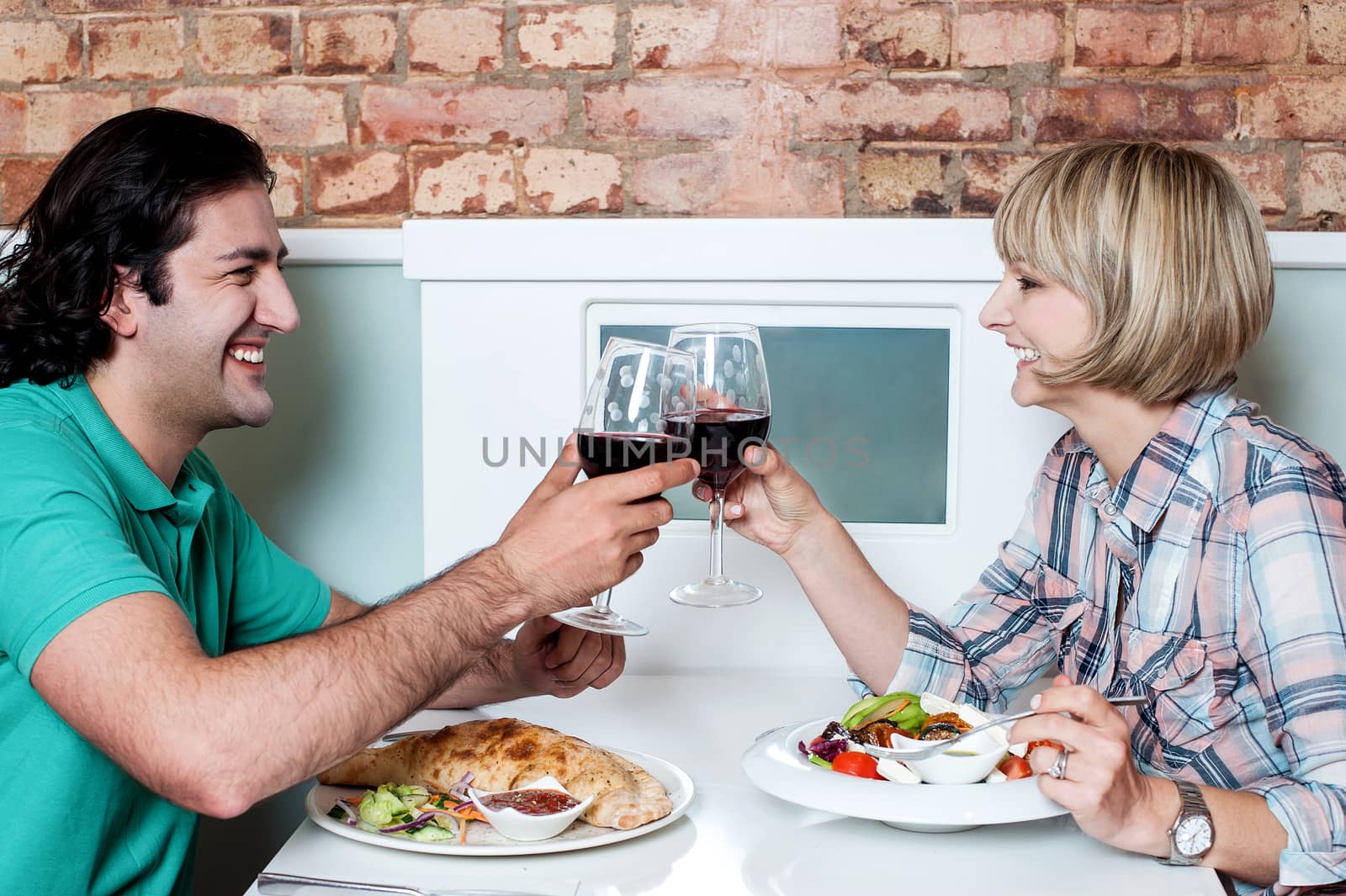 Beautiful couple toasting with wine in restaurant