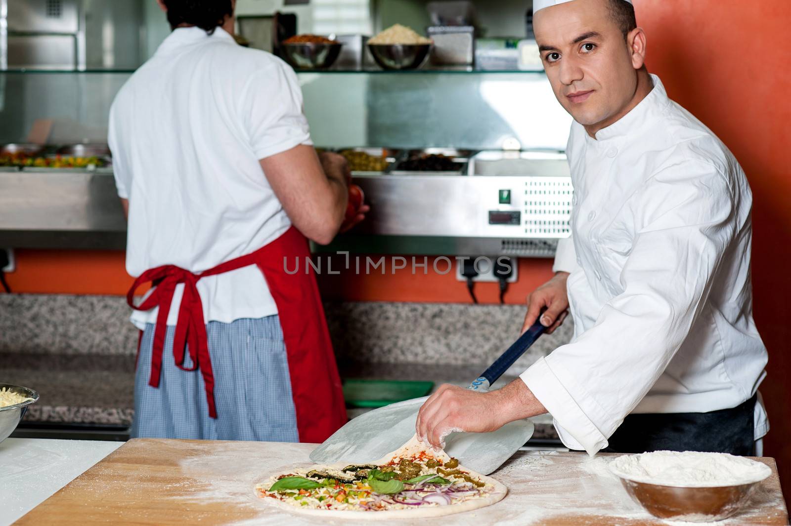 Chef trying to take outthe pizza