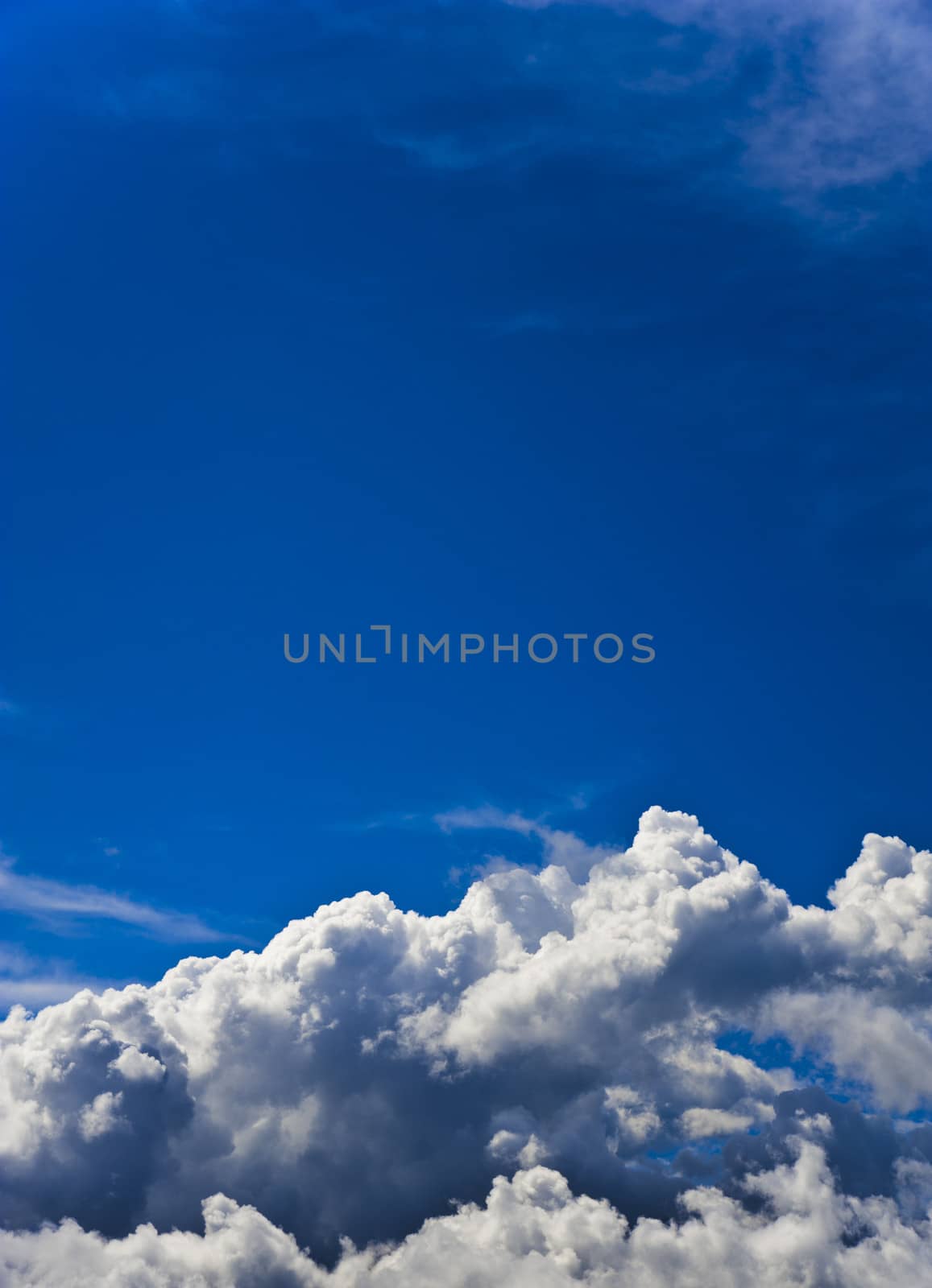 Vertical image of a blue sky with white clouds