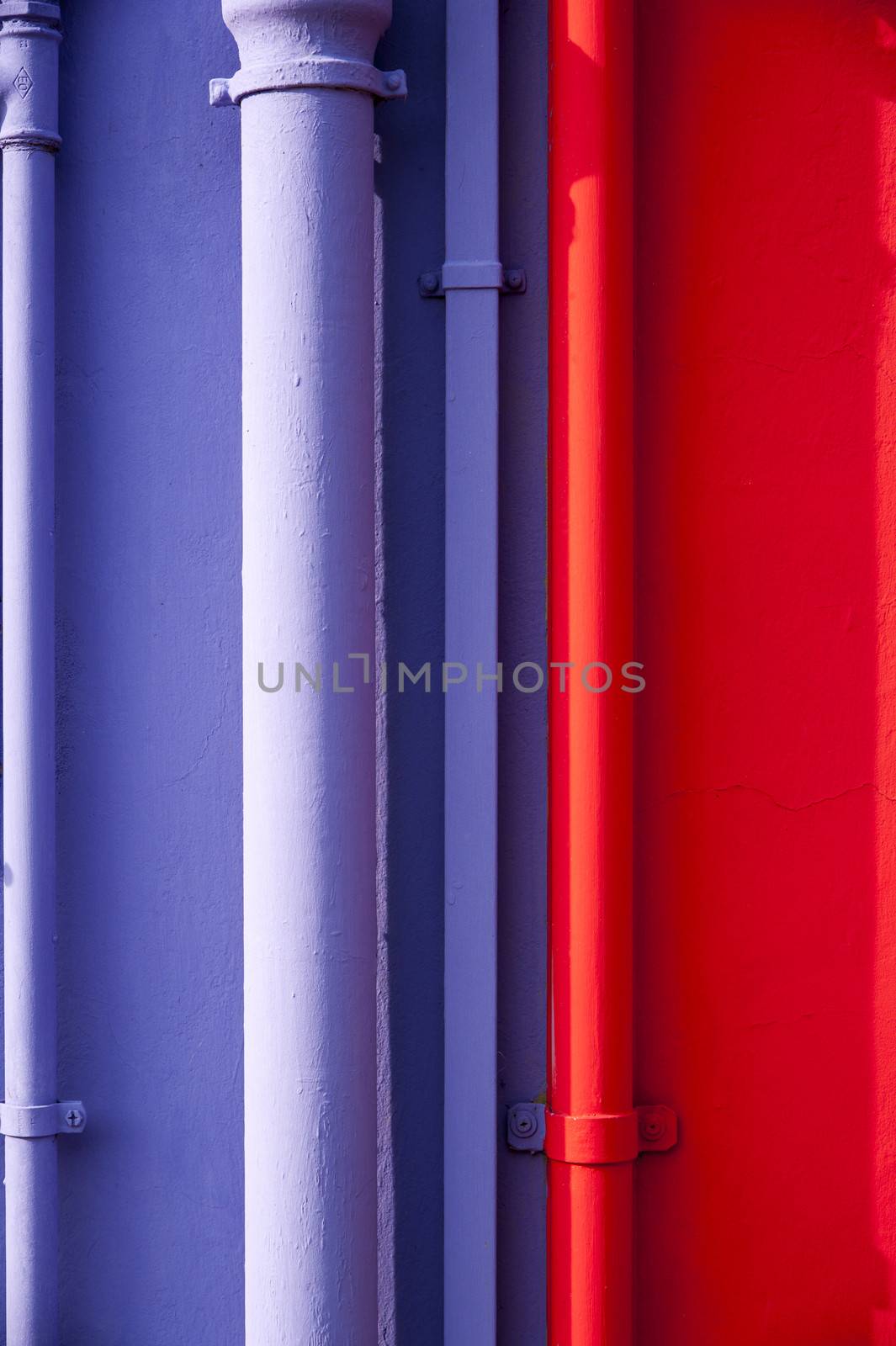 Blue and red tubes on colorful wall