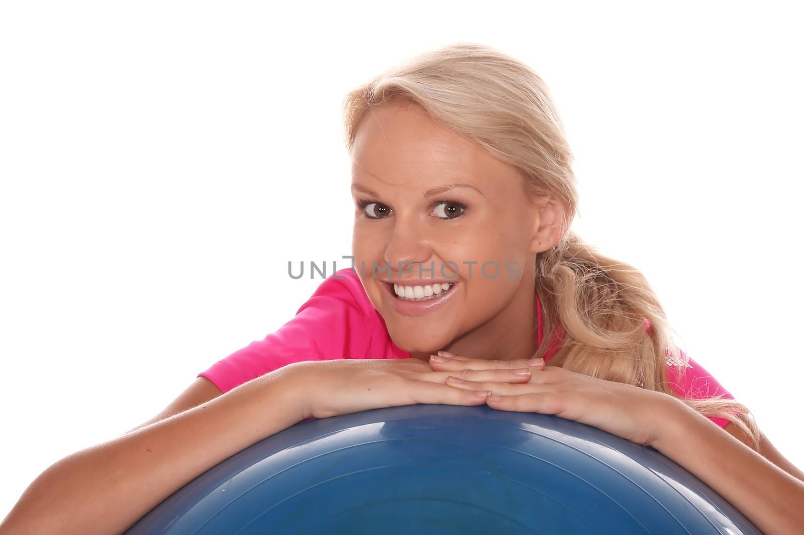 Beautiful young blond lady athlete resting on a blue exercise ball