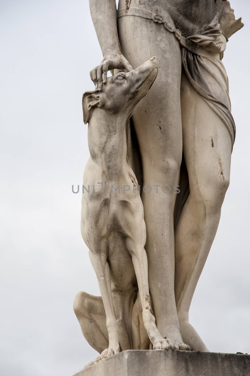 Close up of a statue with dog and a pair of legs