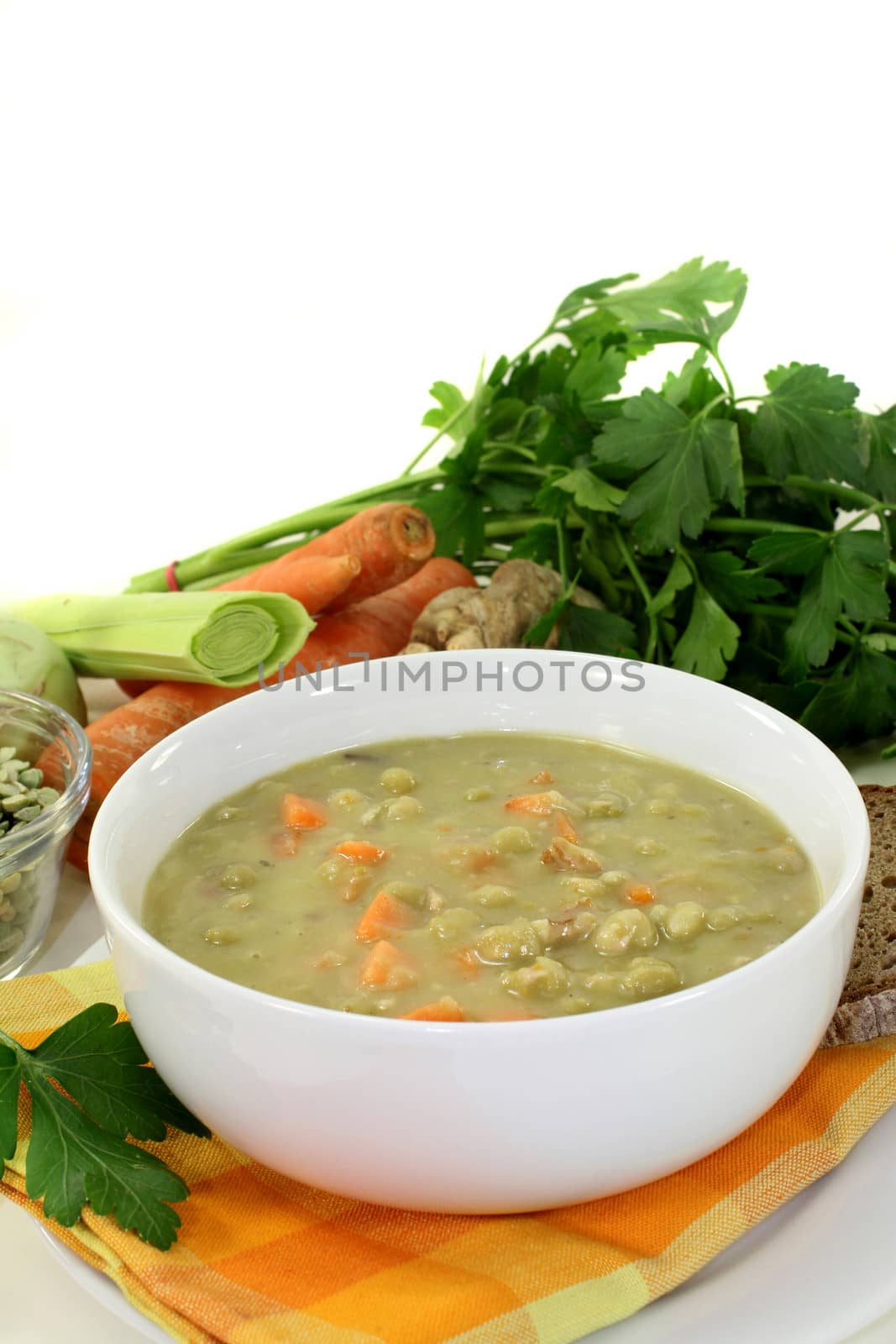 eine wei�e Schale mit Erbseneintopf und Petersilie
a white bowl of pea soup and parsley 