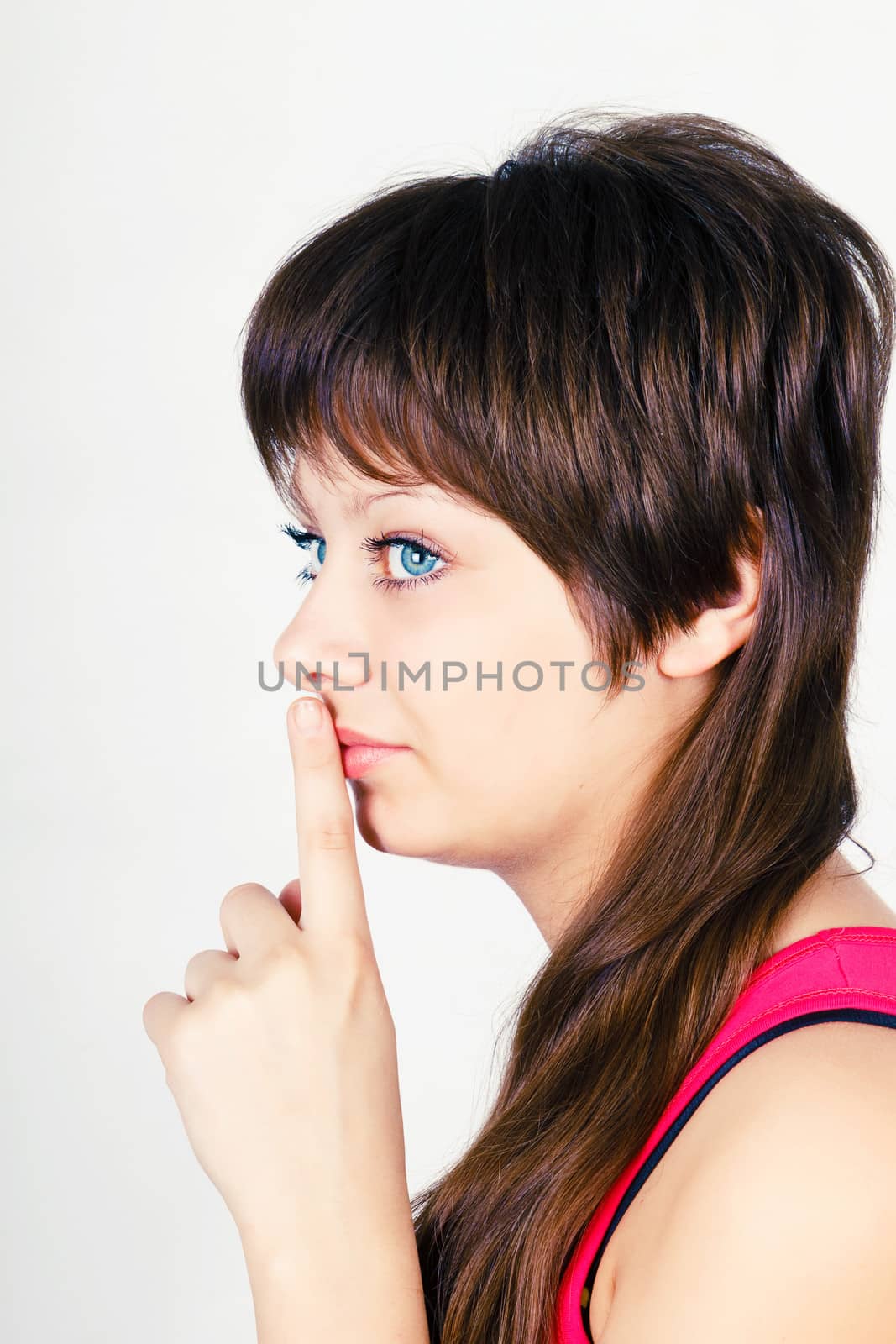 Young attractive girl puts his finger to her lips