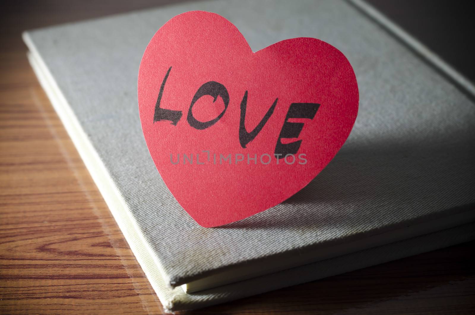 diary of love with notebook and heart on wood background