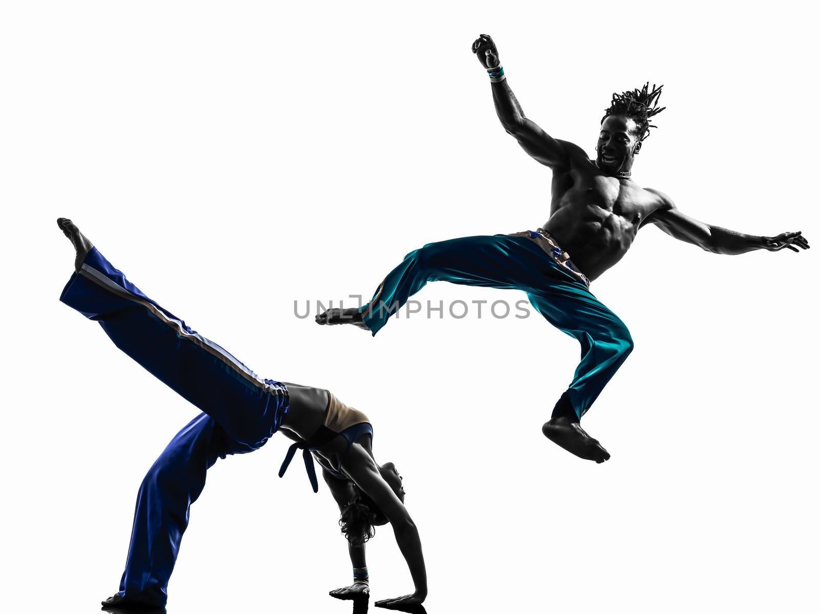 two people couple capoeira dancers dancing in silhouette studio isolated on white background