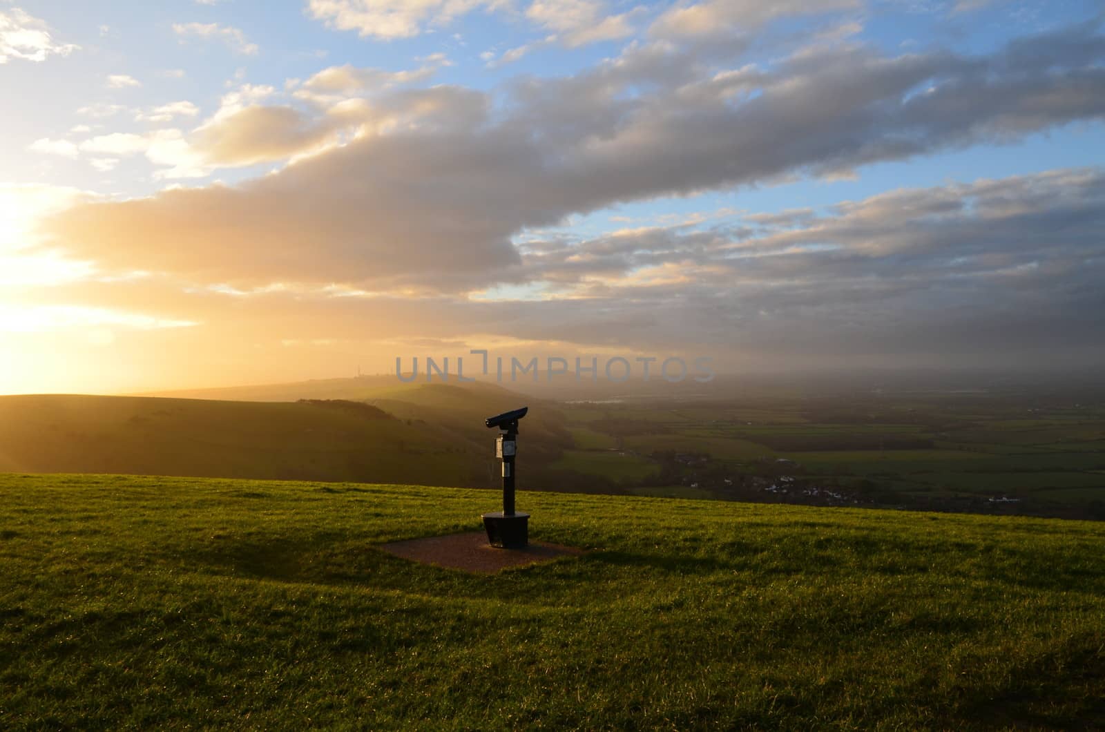 A viewing telescope on the top of a hill overlooking beautiful rolling countryside in Sussex,England.Image taken at Devils Dyke.