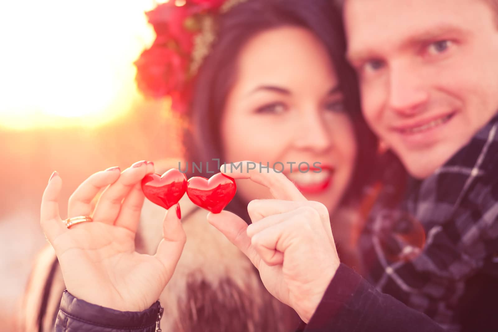 Young couple are holding pair of hearts as a symbol of their love