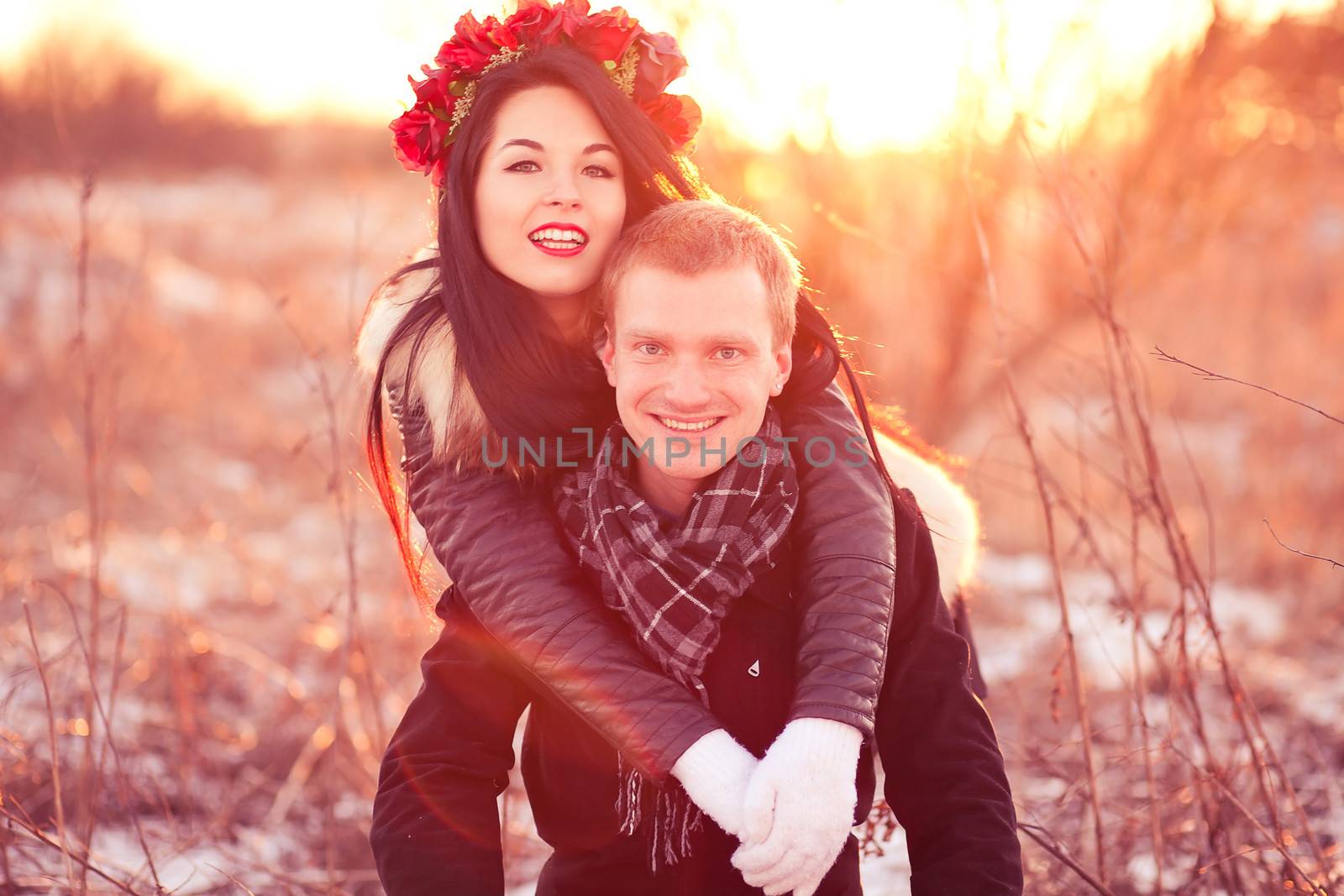 Cheerfull young lovers are smiling and hugging in sunlight