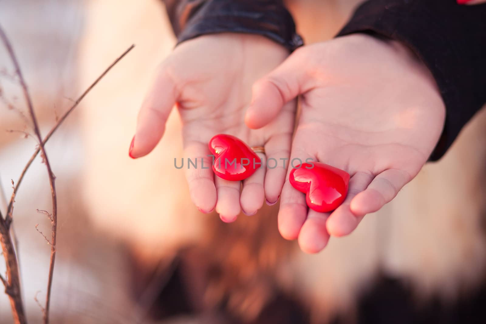 Woman's and men's hands holding pair of hearts as a symbol of love