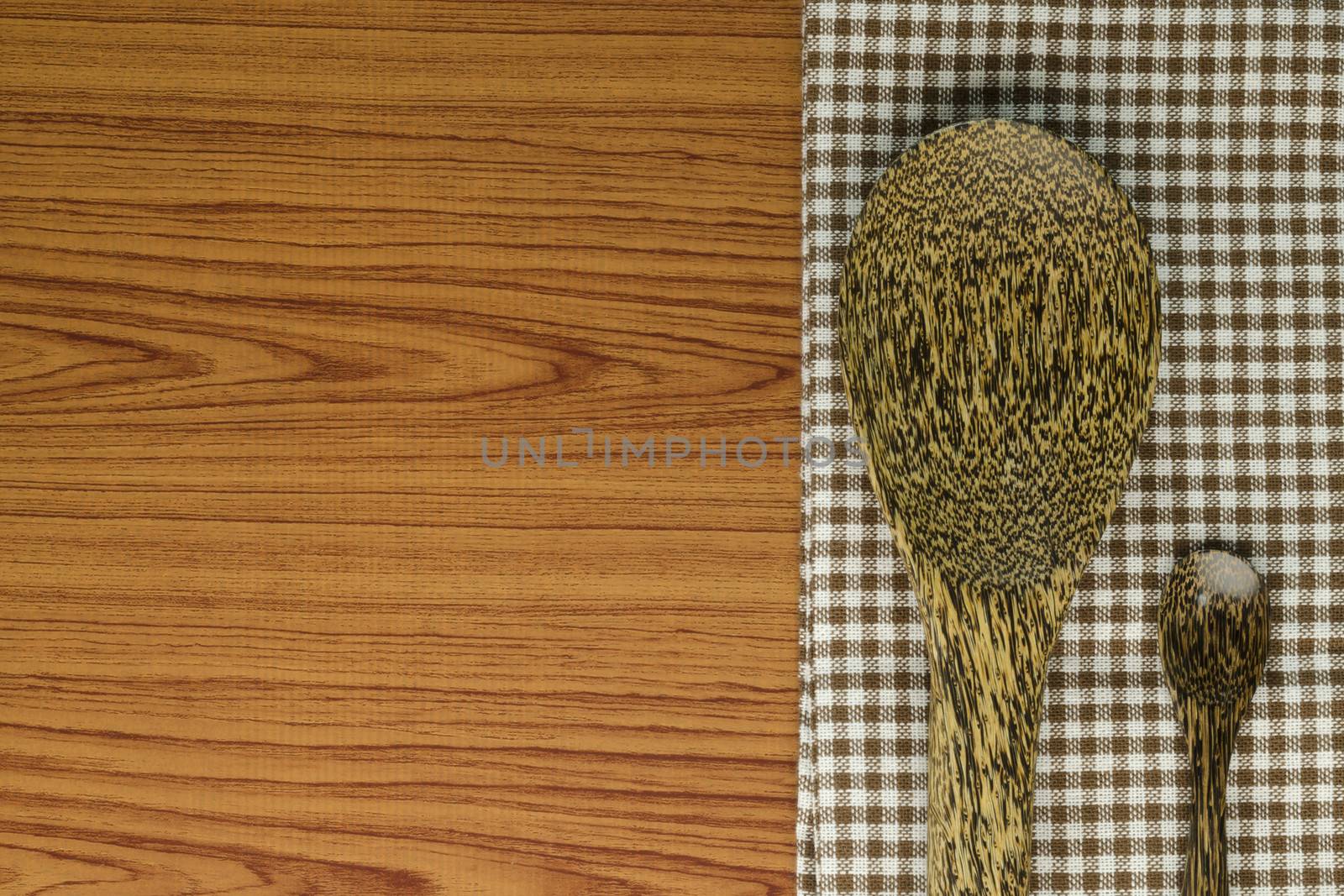 brown kitchen towel with spoon on wood background