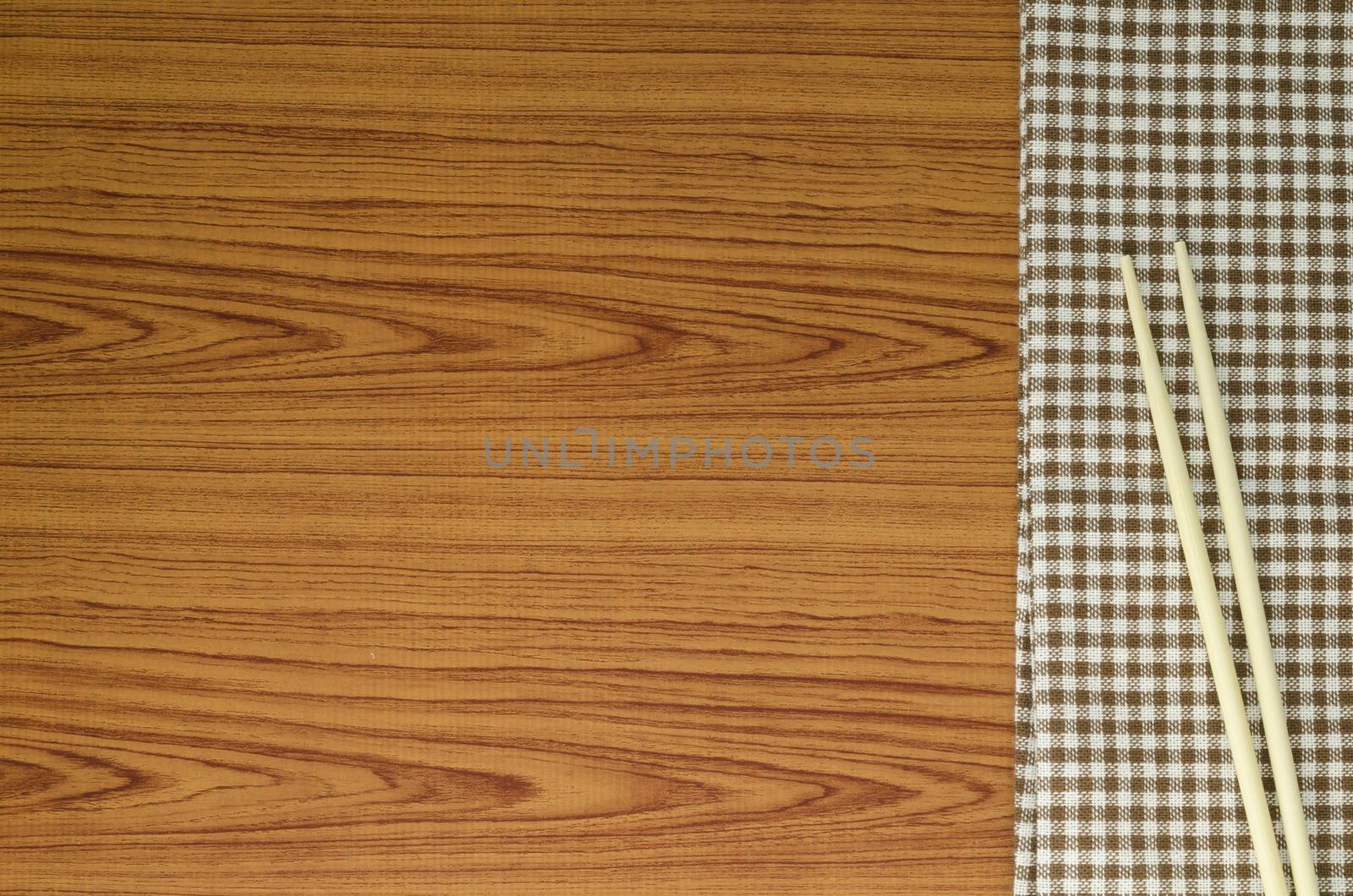 chopsticks with kitchen towel on wood background