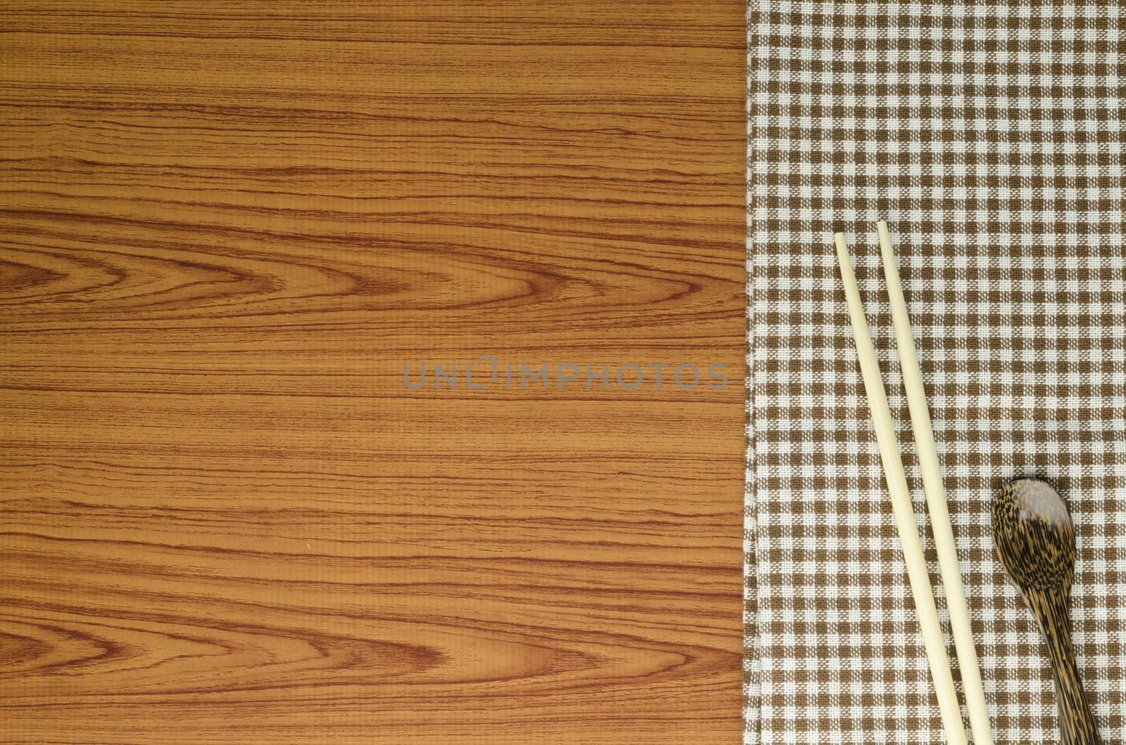 brown kitchen towel with spoon on wood background