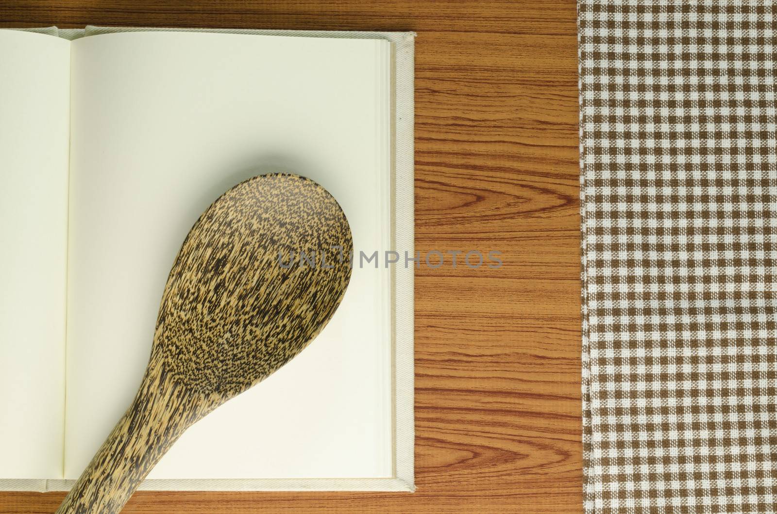 brown kitchen towel with spoon on wood background