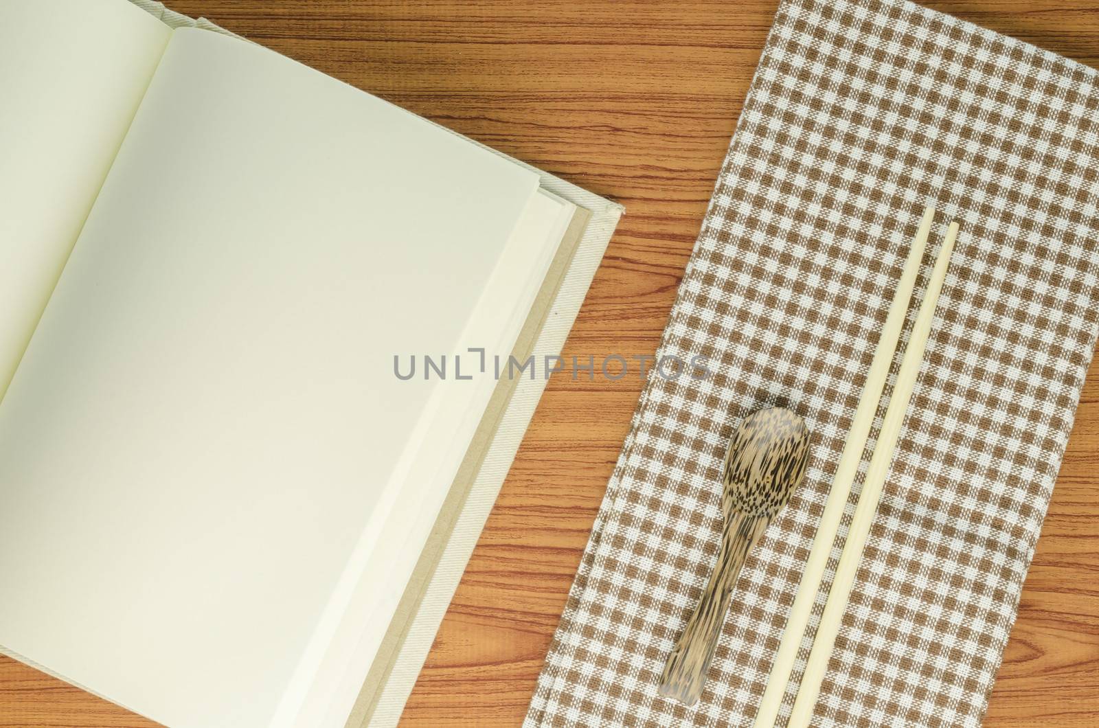 brown kitchen towel with spoon on wood background