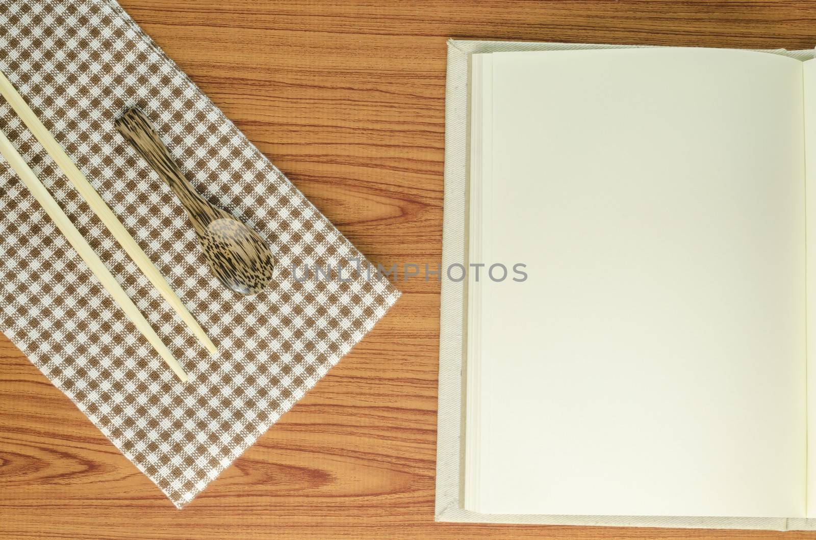 brown kitchen towel with spoon on wood background