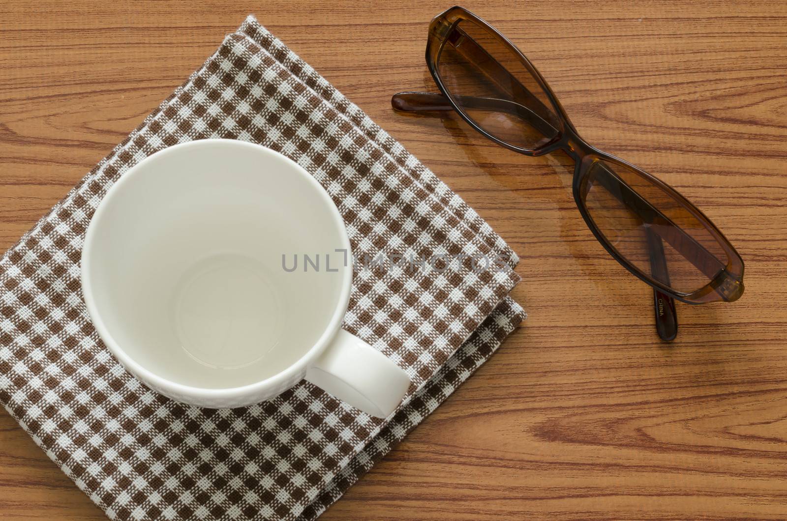 empty coffee cup on brown kitchen towel and wood table