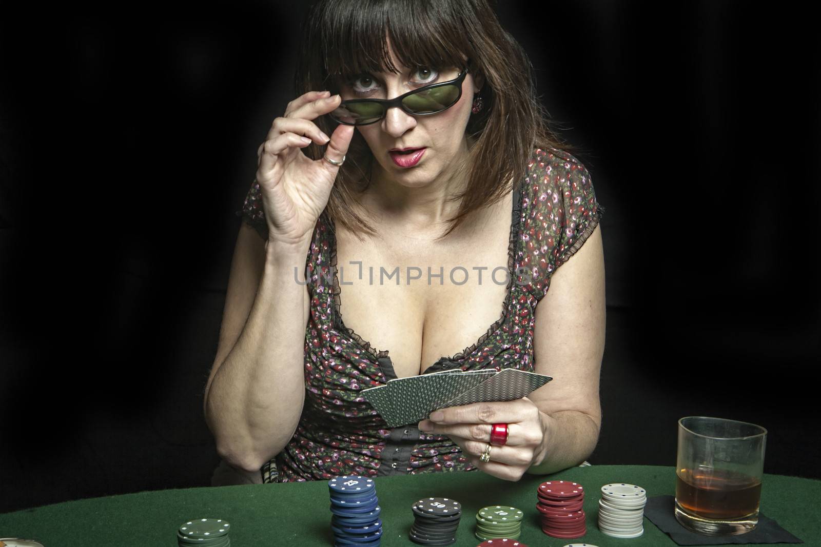 Attractive woman subject his sunglasses while playing a game of poker