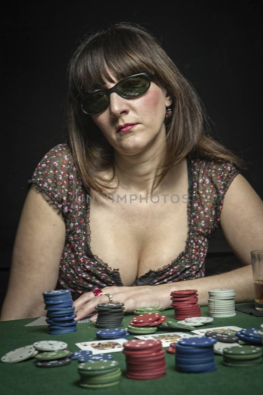 Attractive woman subject his sunglasses while playing a game of poker