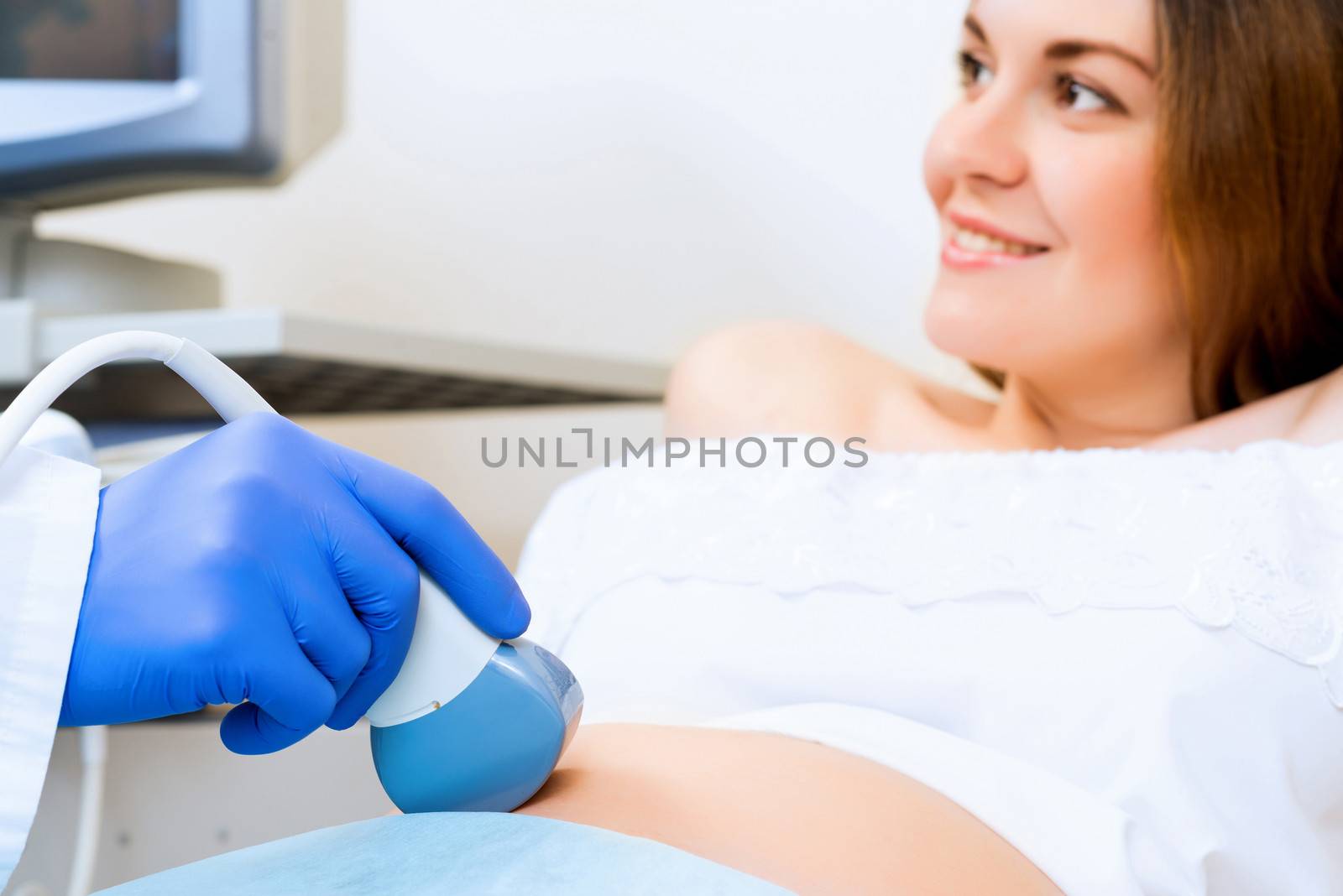 close-up of hands and abdominal ultrasound scanner for pregnant women