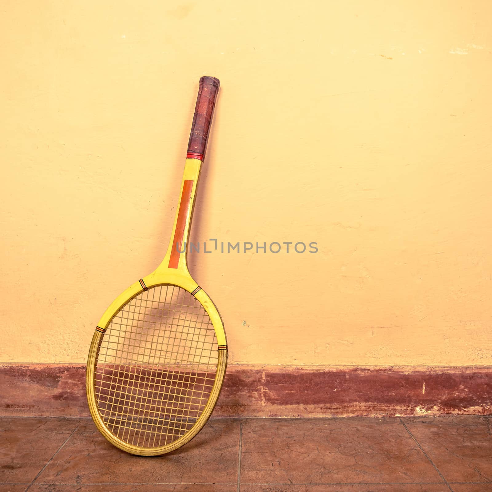 Vintage tennis racket against a wall