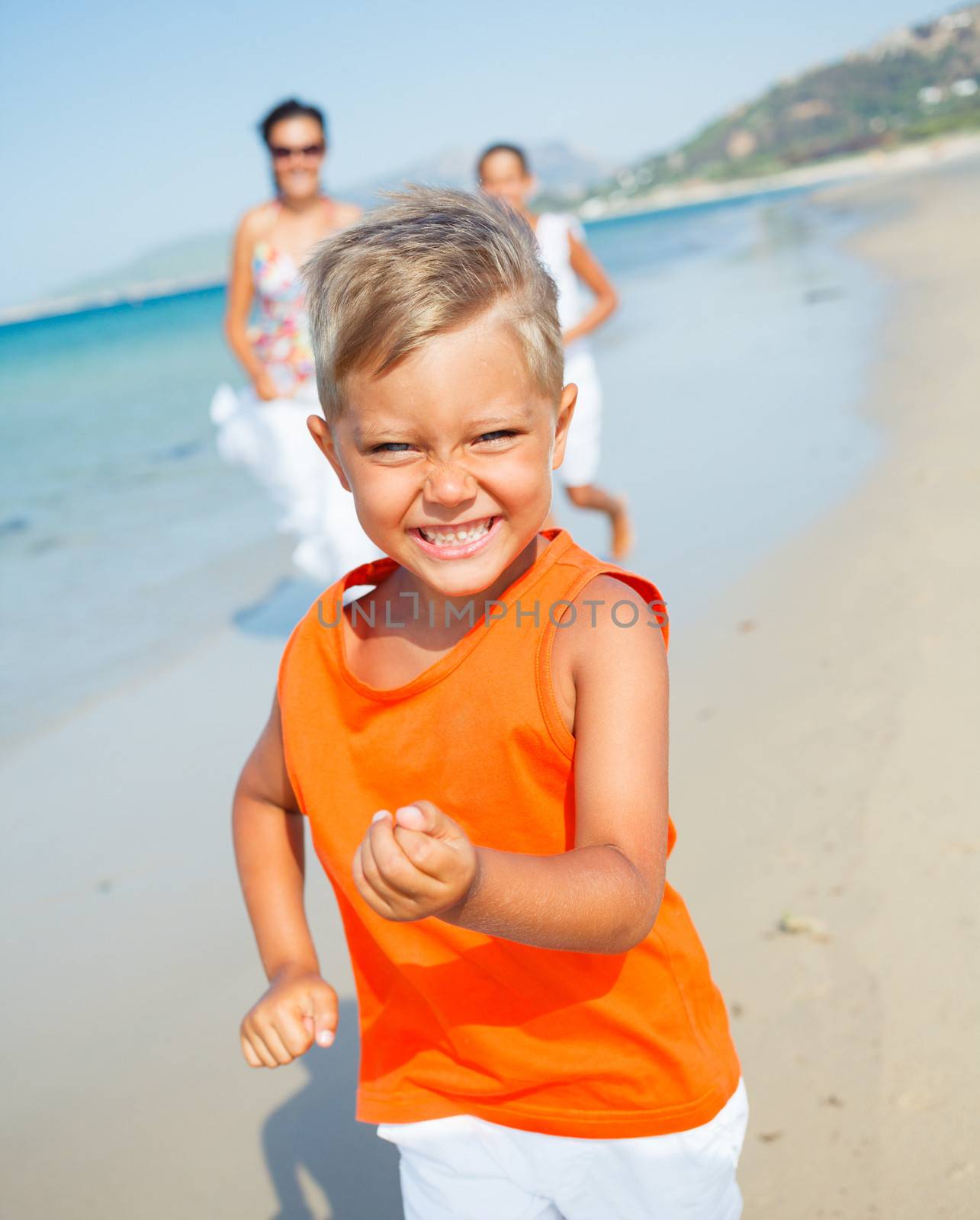 Cute boy with sister and mother on the beach by maxoliki