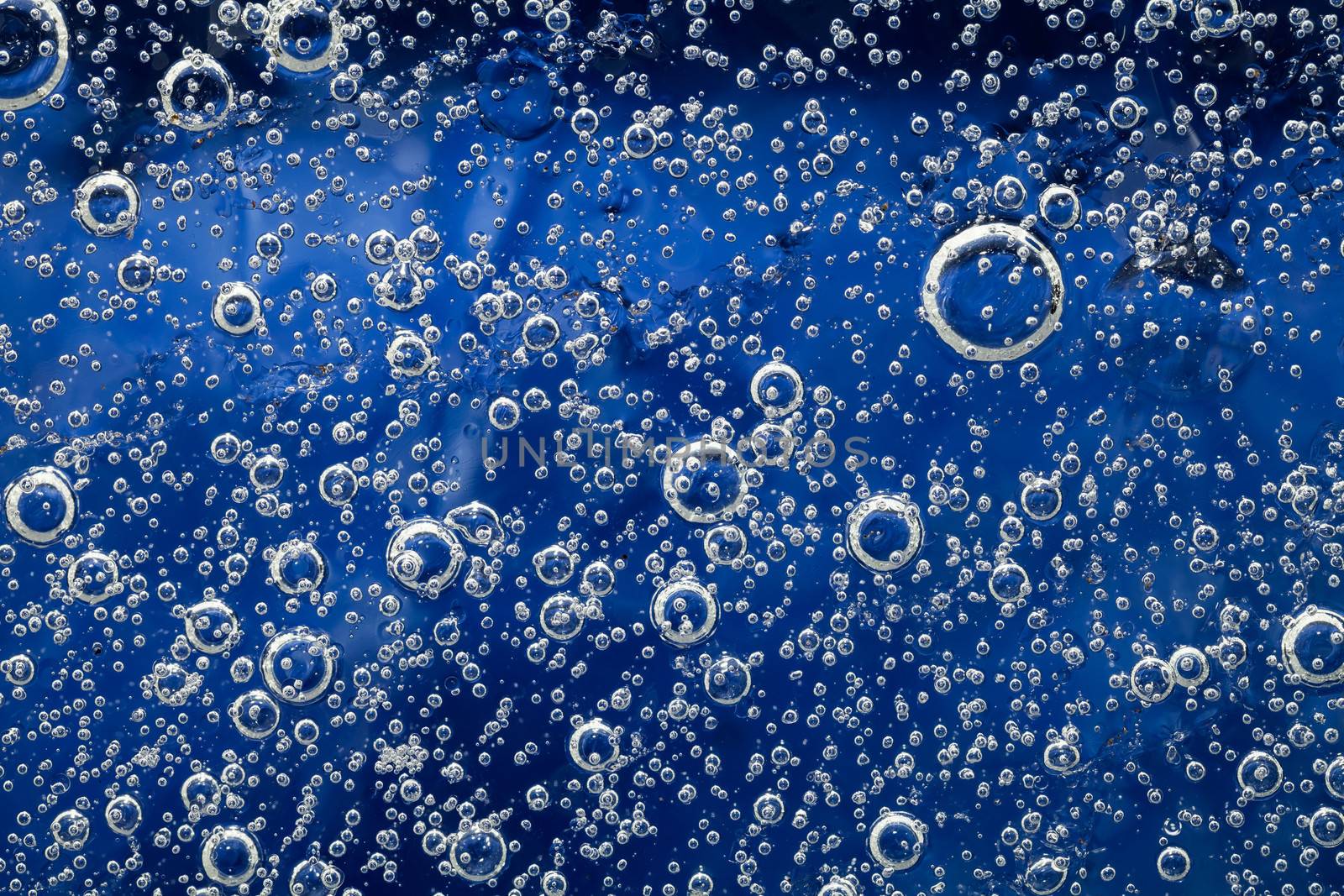 Ice background with bubbles. Natural blue texture of ice