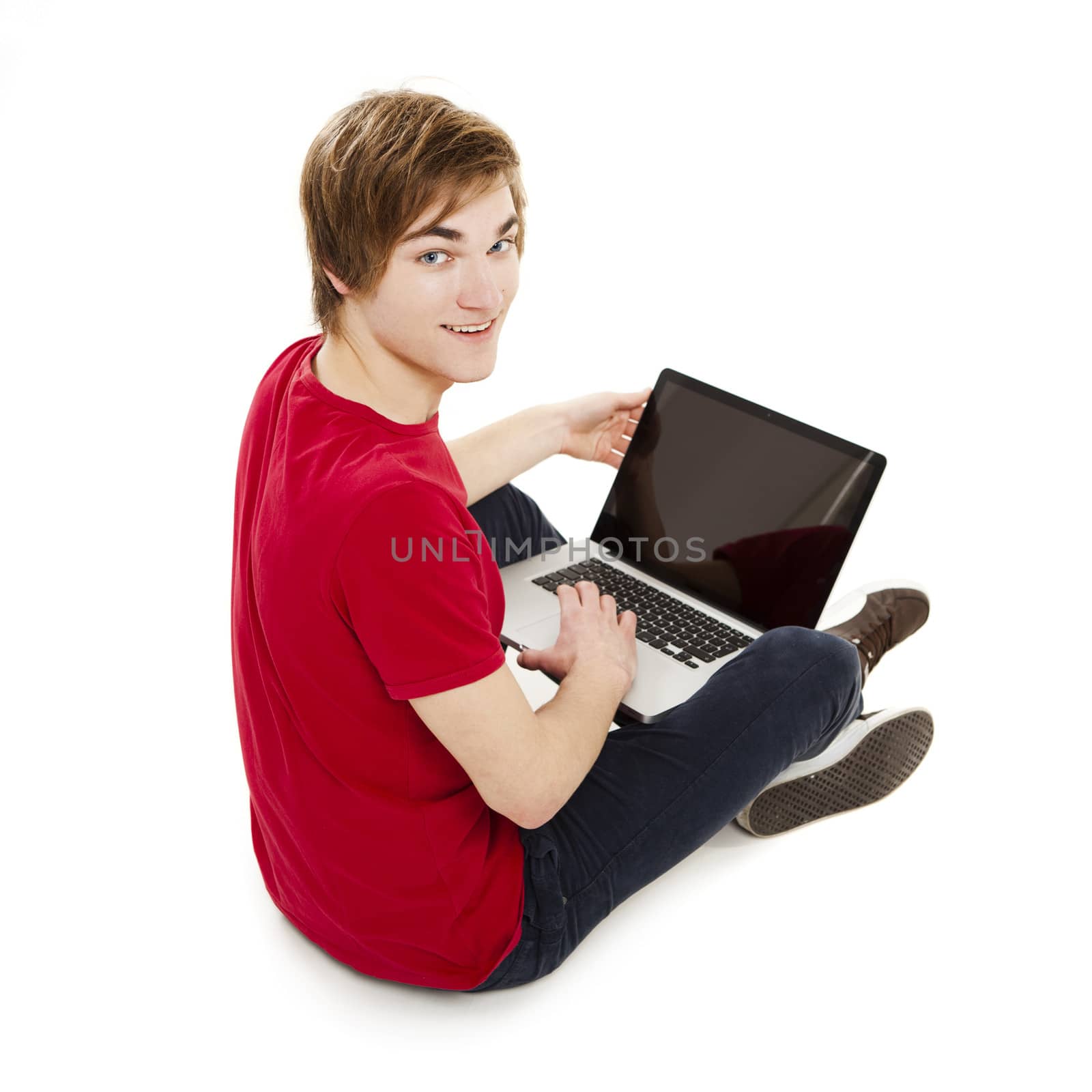 Young man sitting in the floor and working with a laptop