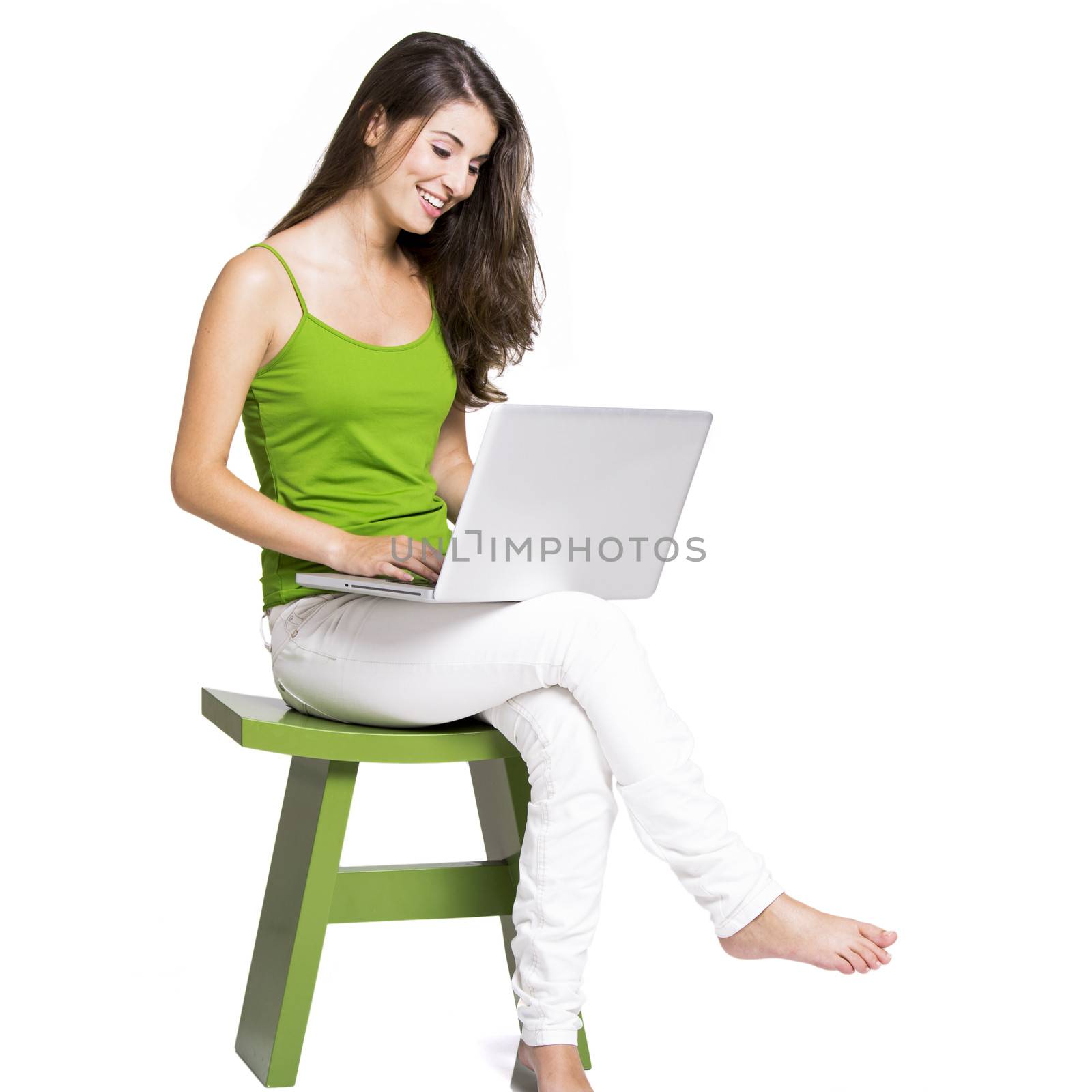Beautiful woman sitting in a chair working with a laptop, isolated over a white