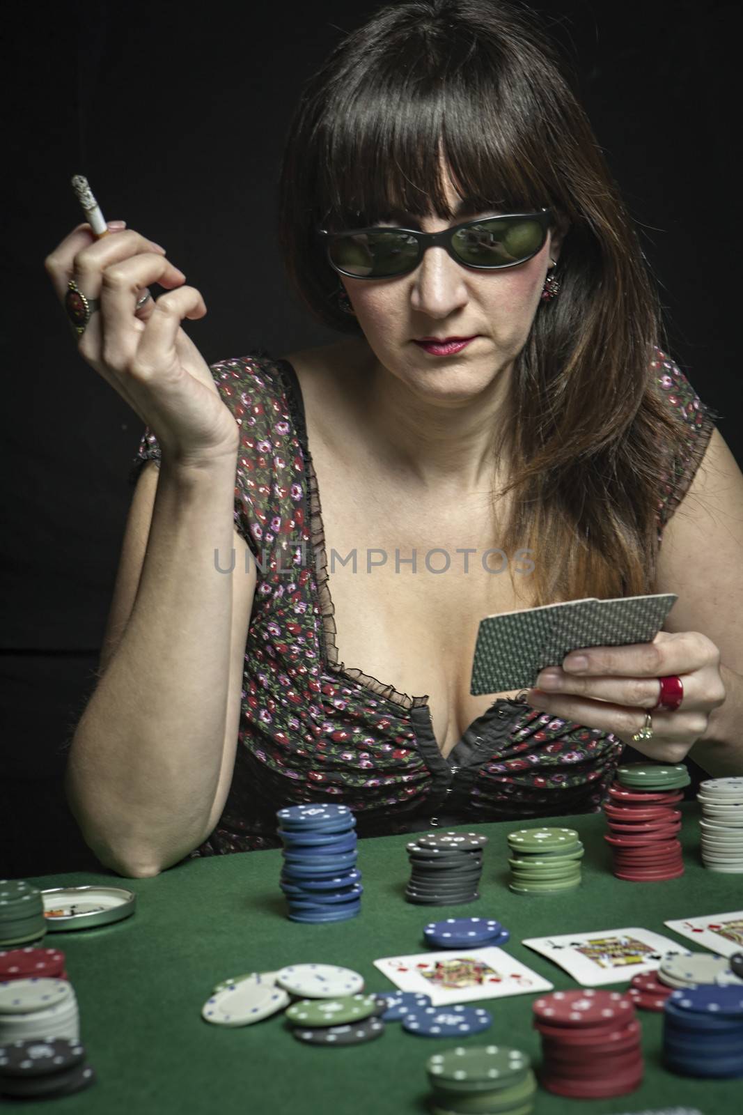 Sexy Woman with cigarette and sunglasses bet in a poker game by digicomphoto