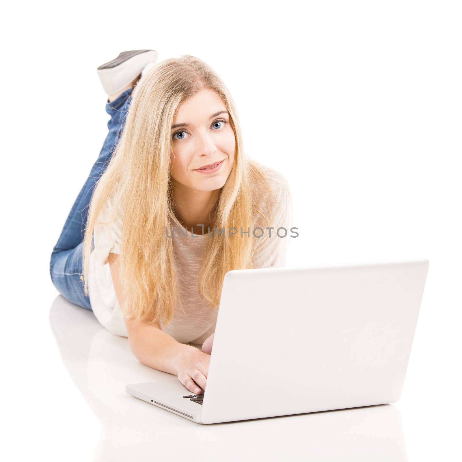 Beautiful woman lying on the floor and working with a laptop, isolated over white background