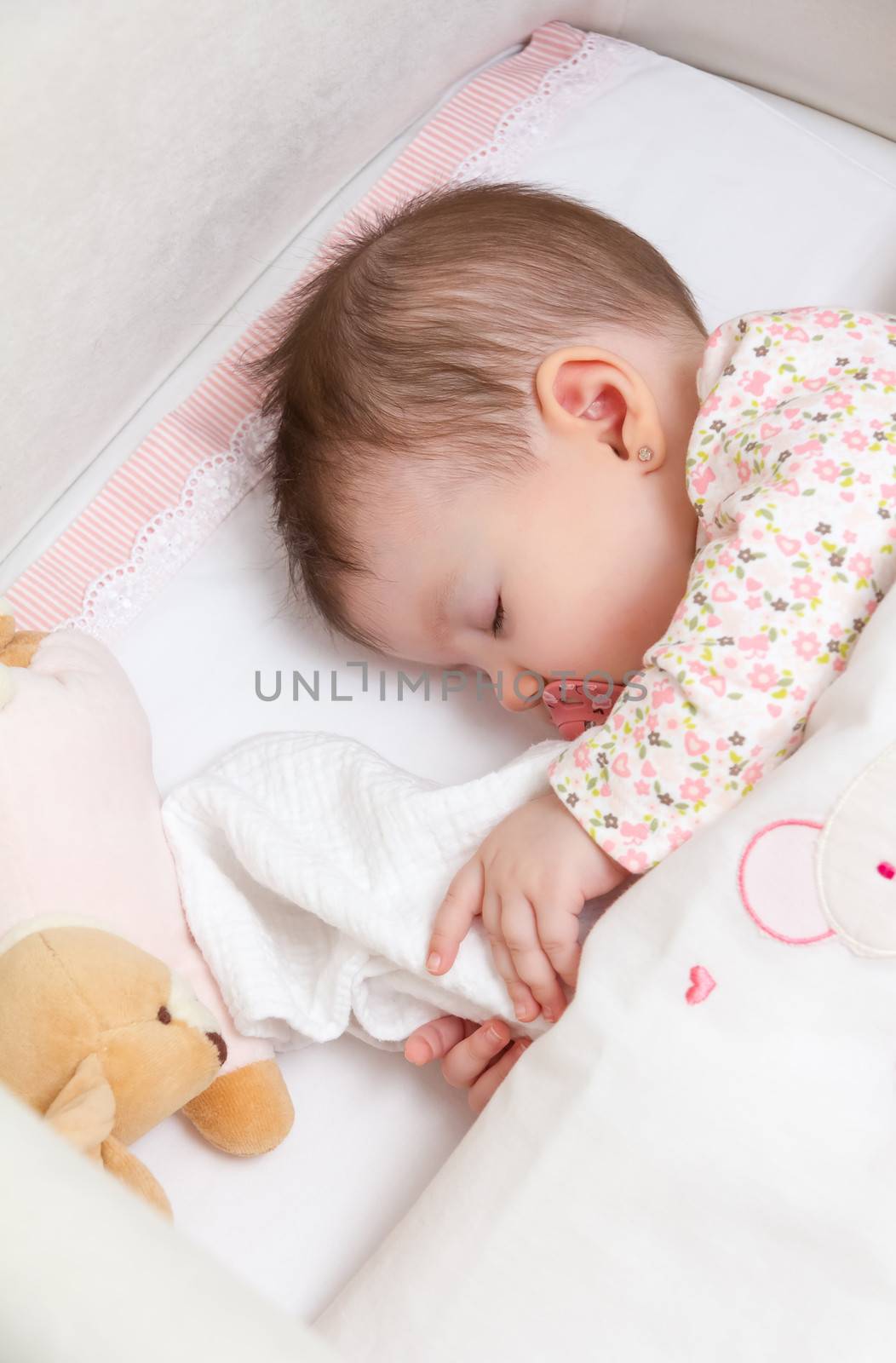Baby girl sleeping in a cot with pacifier and toy by doble.d