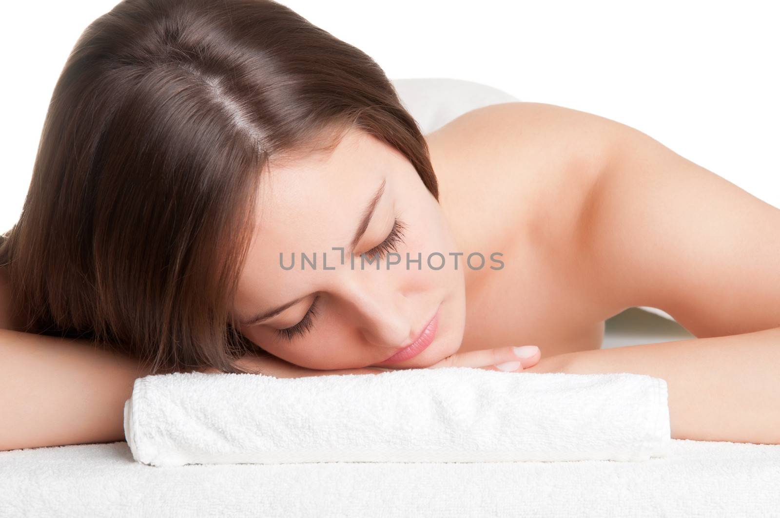 Young woman lying in a spa ready to get a massage isolated in white