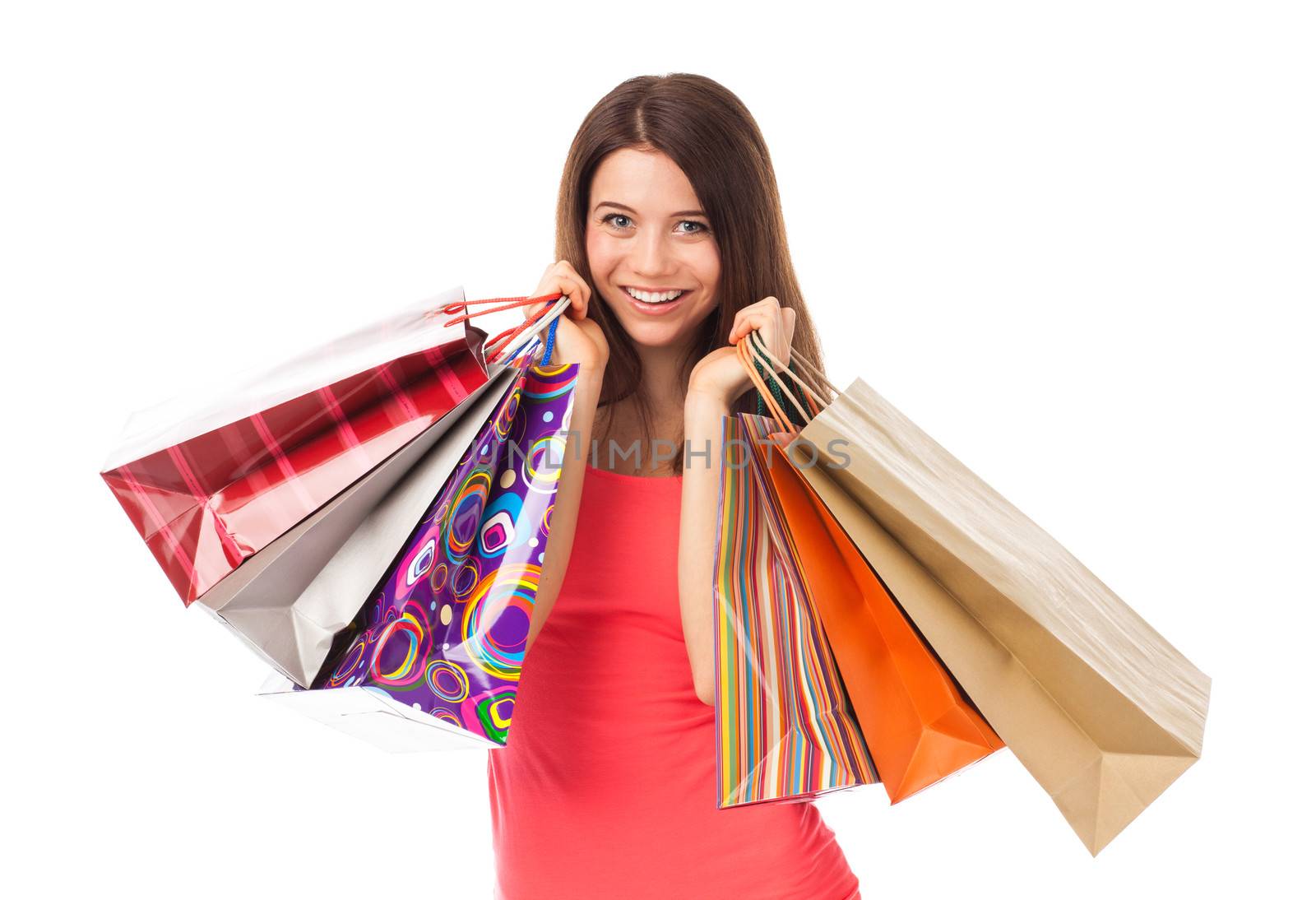 Portrait of a young woman holding shopping bags and smiling, isolated on white